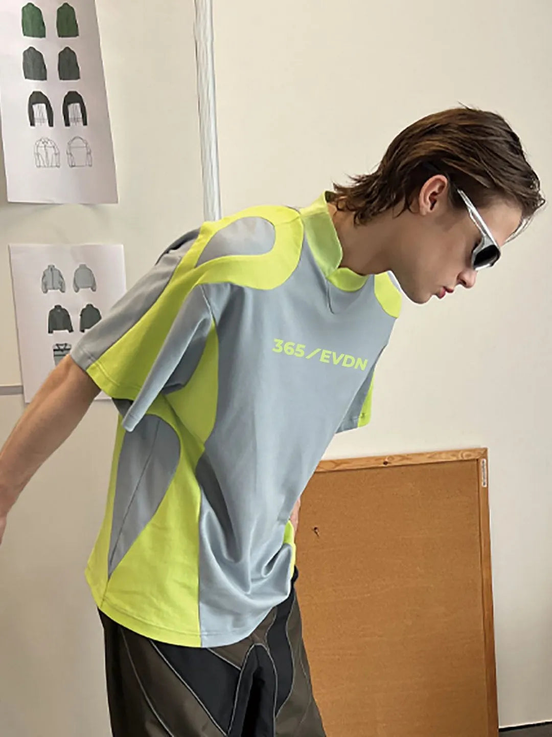 Person wearing a reflective safety shirt with '365 EVDN' branding in an indoor setting.