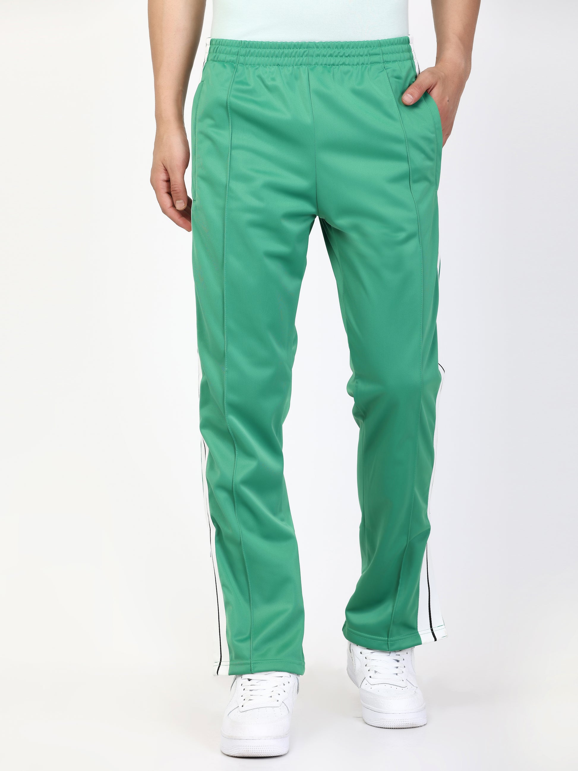 Green track pants with white side stripes and an elasticated waistband, with pockets.