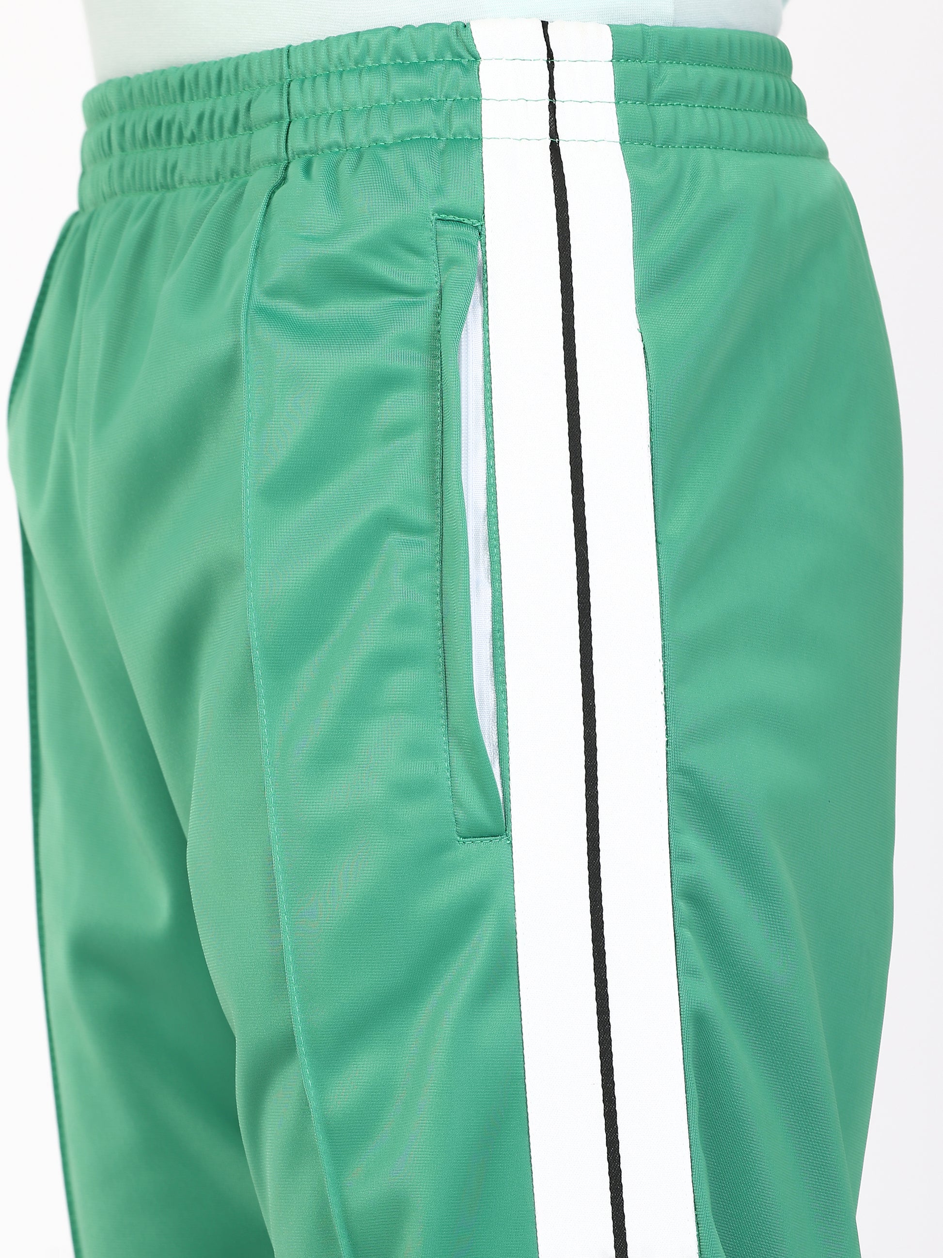 Green track pants with white side stripes and an elasticated waistband, with pockets.