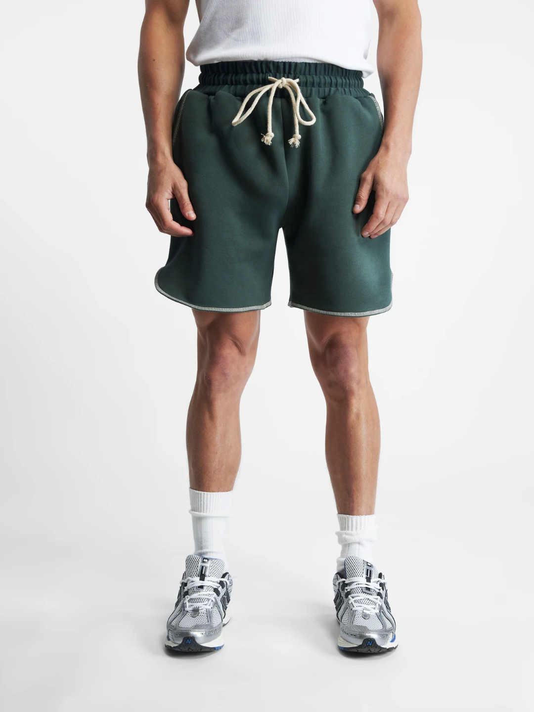A pair of Green overlock running shorts with a drawstring waistband, shown in a flat lay on a white background.