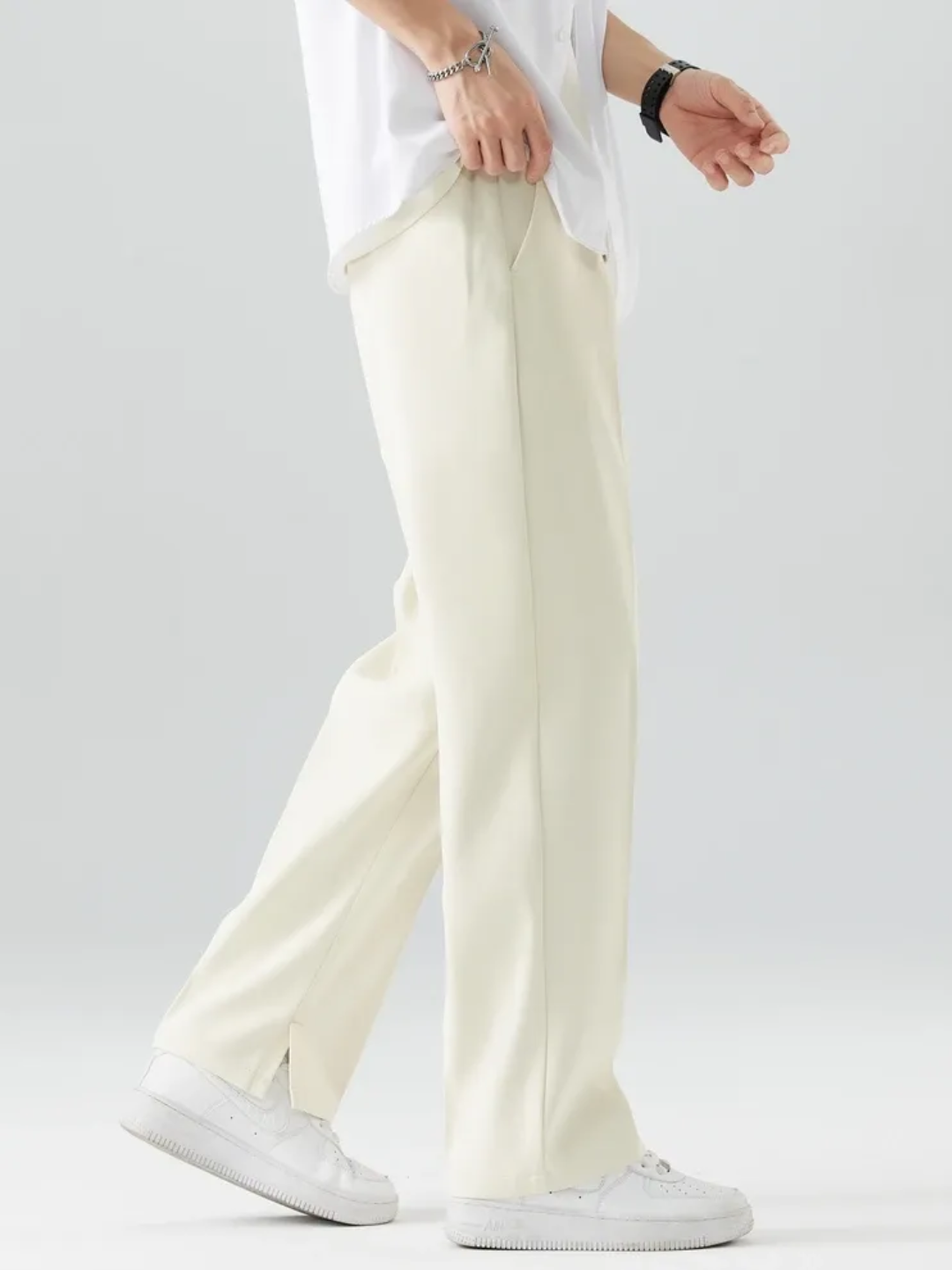 A person wearing White Tek Air loose fit pants and a white shirt, standing against a white background.