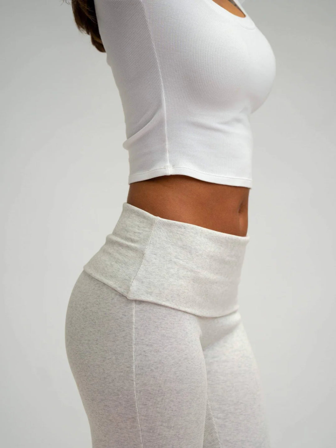 A pair of grey flare leggings on a female model, viewed from the waist down.