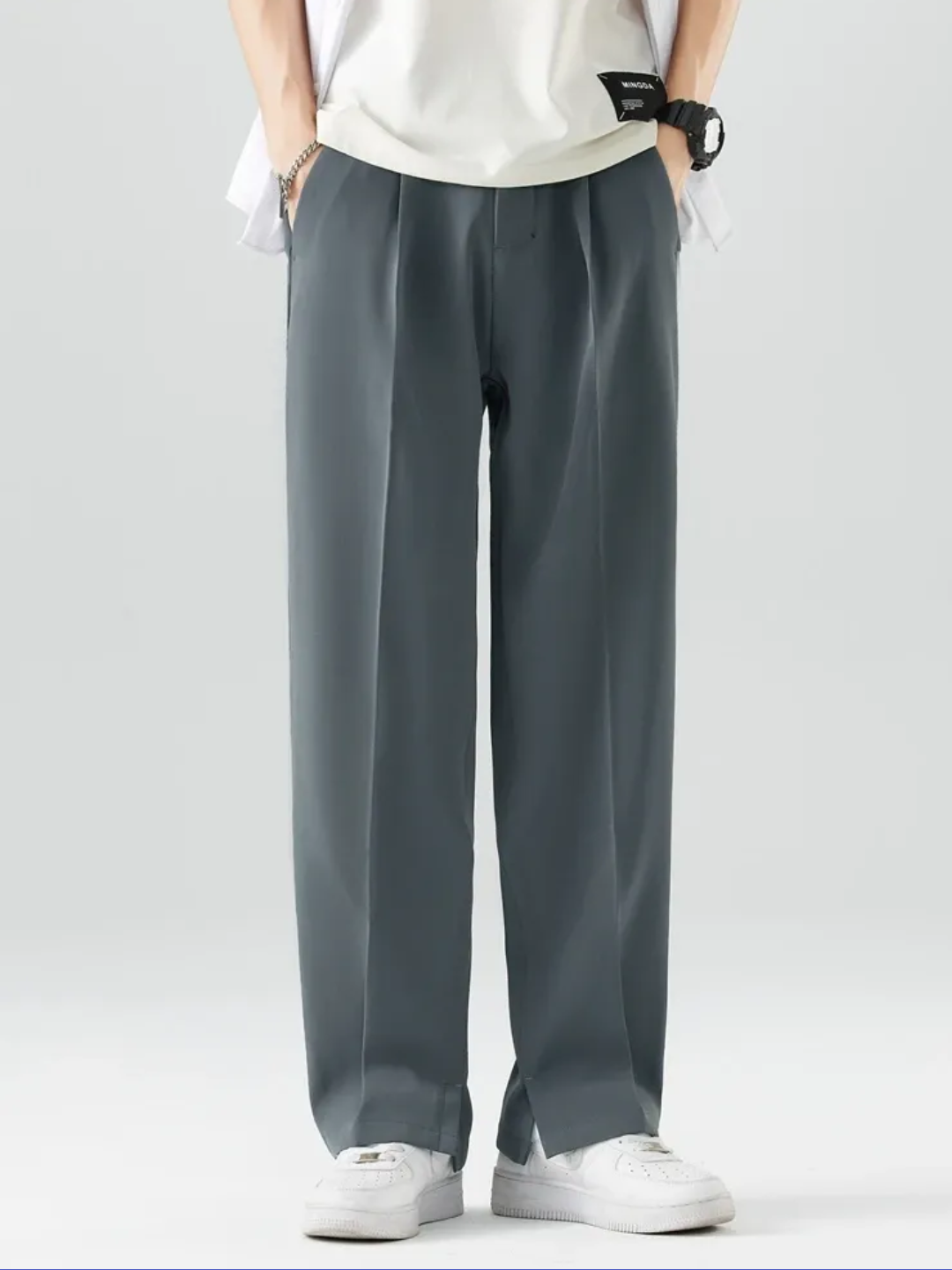 A person wearing Grey Tek Air loose fit pants and a white shirt, standing against a white background.