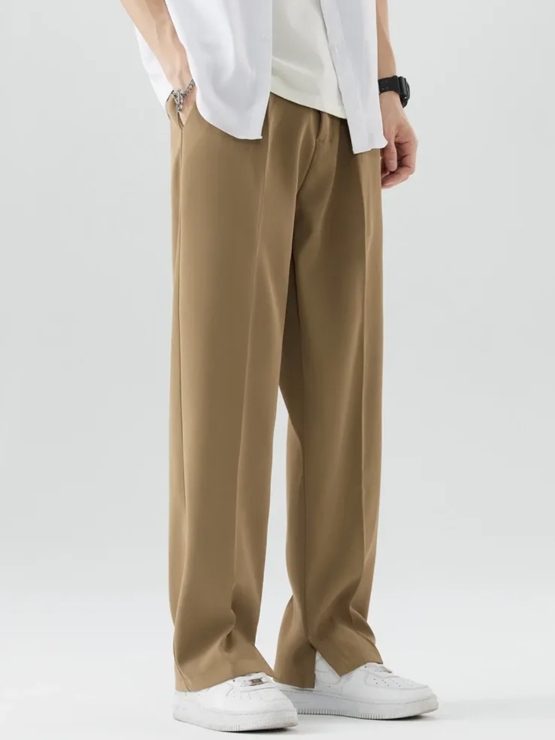 A person wearing brown Tek Air loose fit pants and a white shirt, standing against a white background.