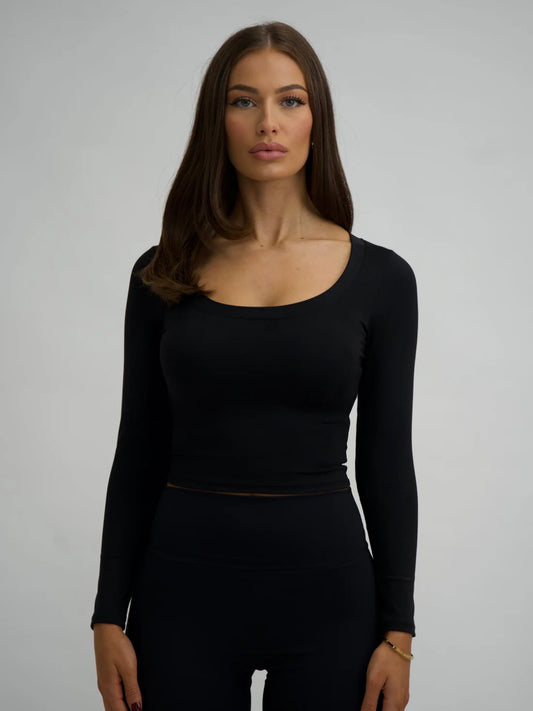 This image features a stylish black long sleeve top, crafted from comfortable lycra fabric. The top, which is form-fitting, showcases a high neck and extends to mid-calf length, providing both a flattering fit and a fashionable look.
