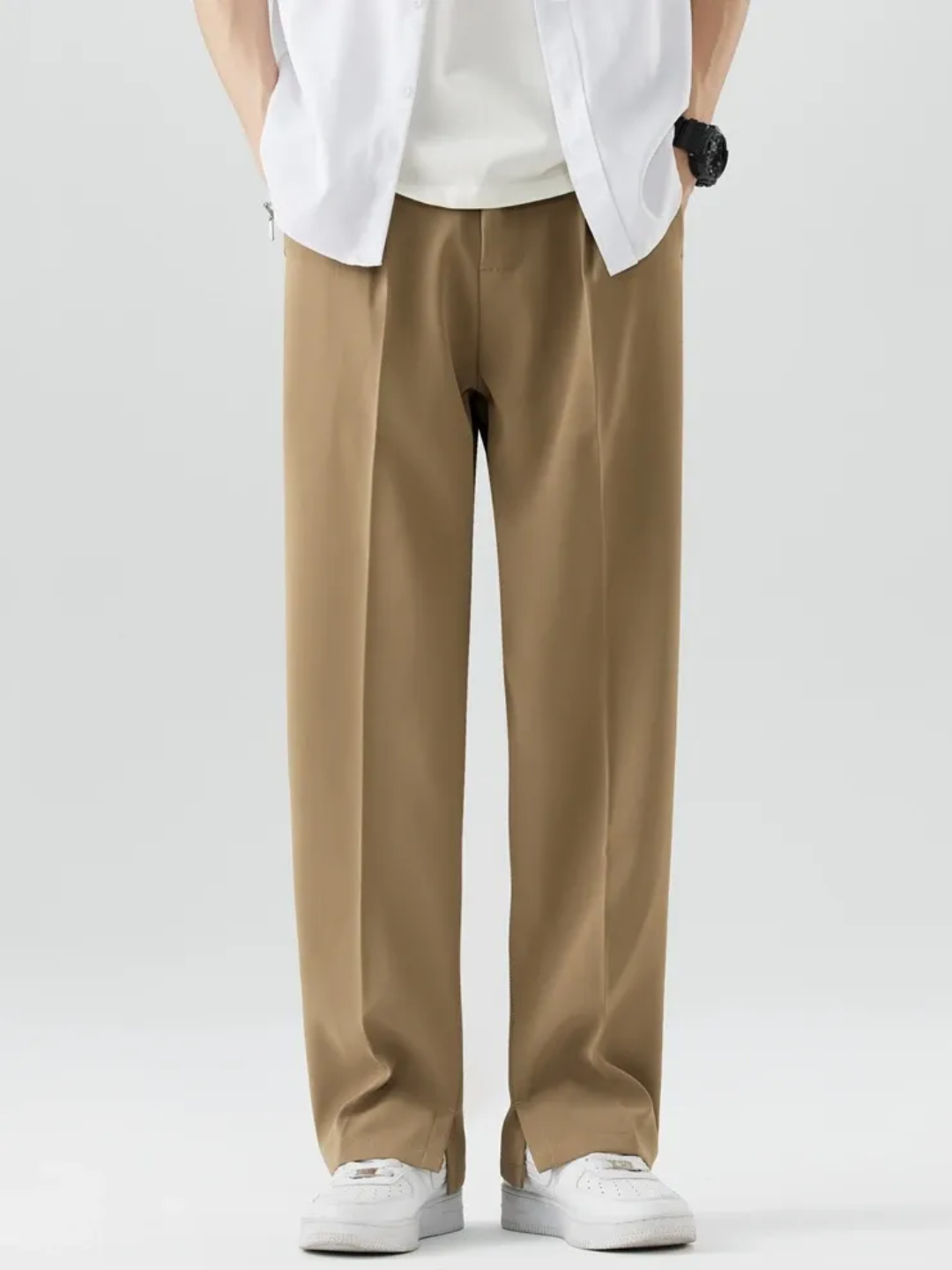 A person wearing brown Tek Air loose fit pants and a white shirt, standing against a white background.