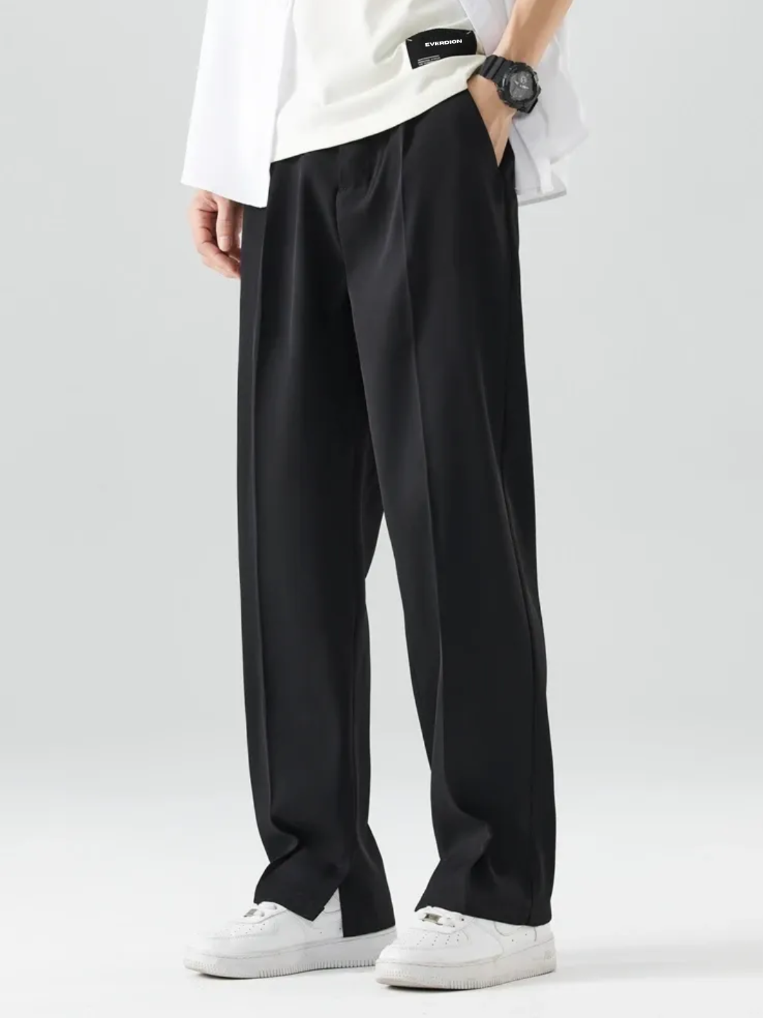 A person wearing Black Tek Air loose fit pants and a white shirt, standing against a white background.