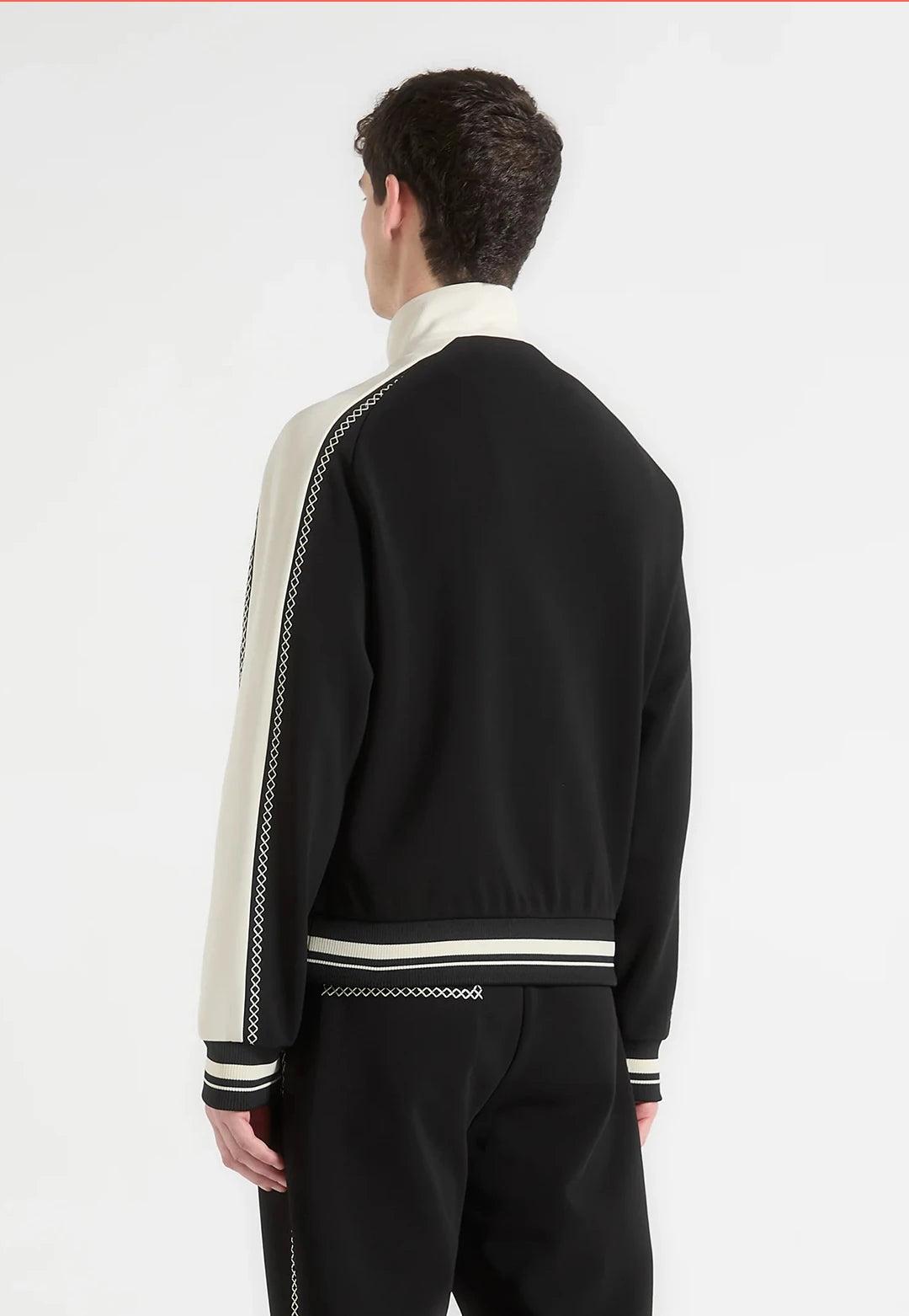 Person wearing a black and white tracksuit on a white background