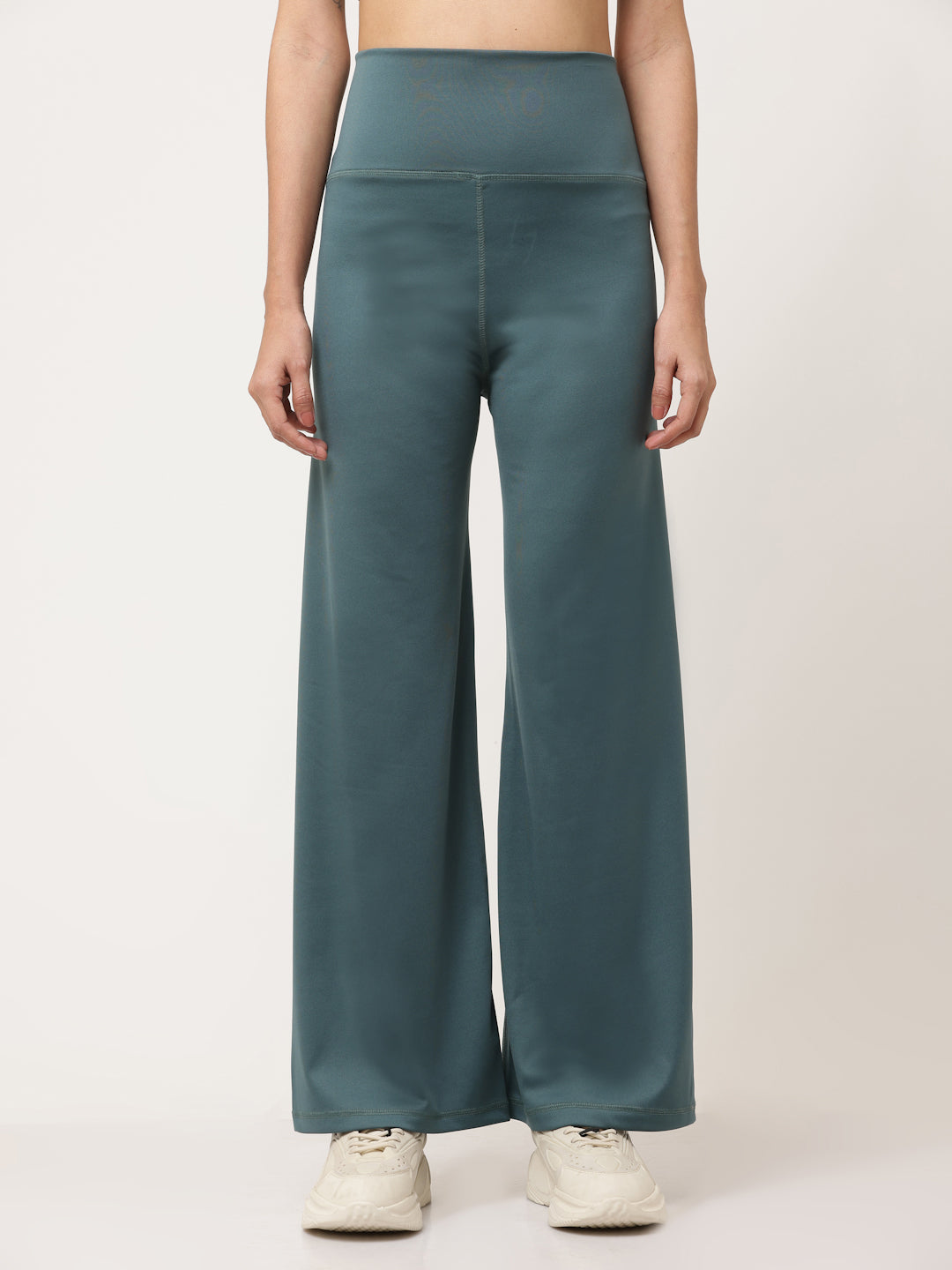 A model wearing green flared high-rise full-length yoga pants with a solid pattern.