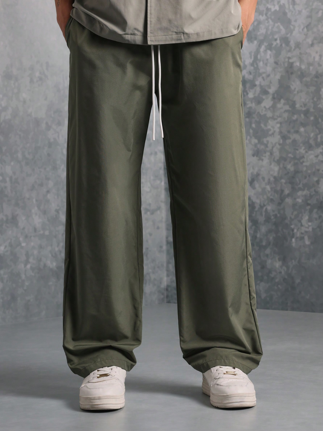 This image features the Chateau Boxy Fit Shirt and Pant set, presenting a stylish and relaxed outfit. The shirt is short-sleeved with a boxy fit and features two chest pockets, in a light grey color that complements the darker green pants.