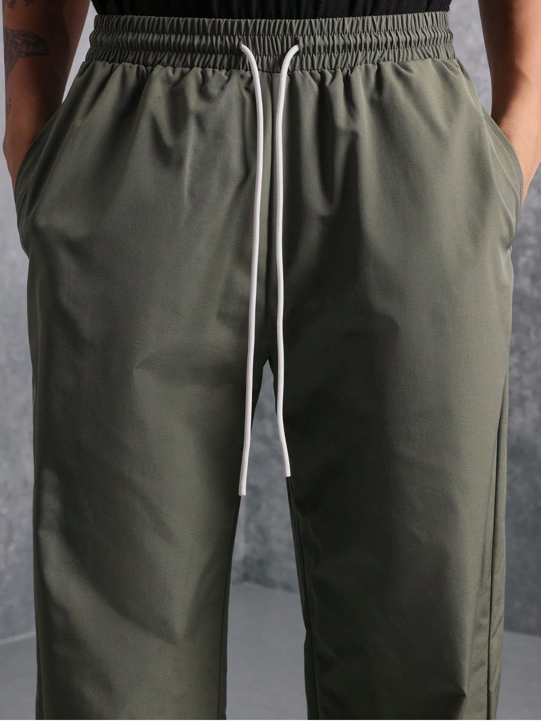 This image features the Chateau Boxy Fit Shirt and Pant set, presenting a stylish and relaxed outfit. The shirt is short-sleeved with a boxy fit and features two chest pockets, in a light grey color that complements the darker green pants.