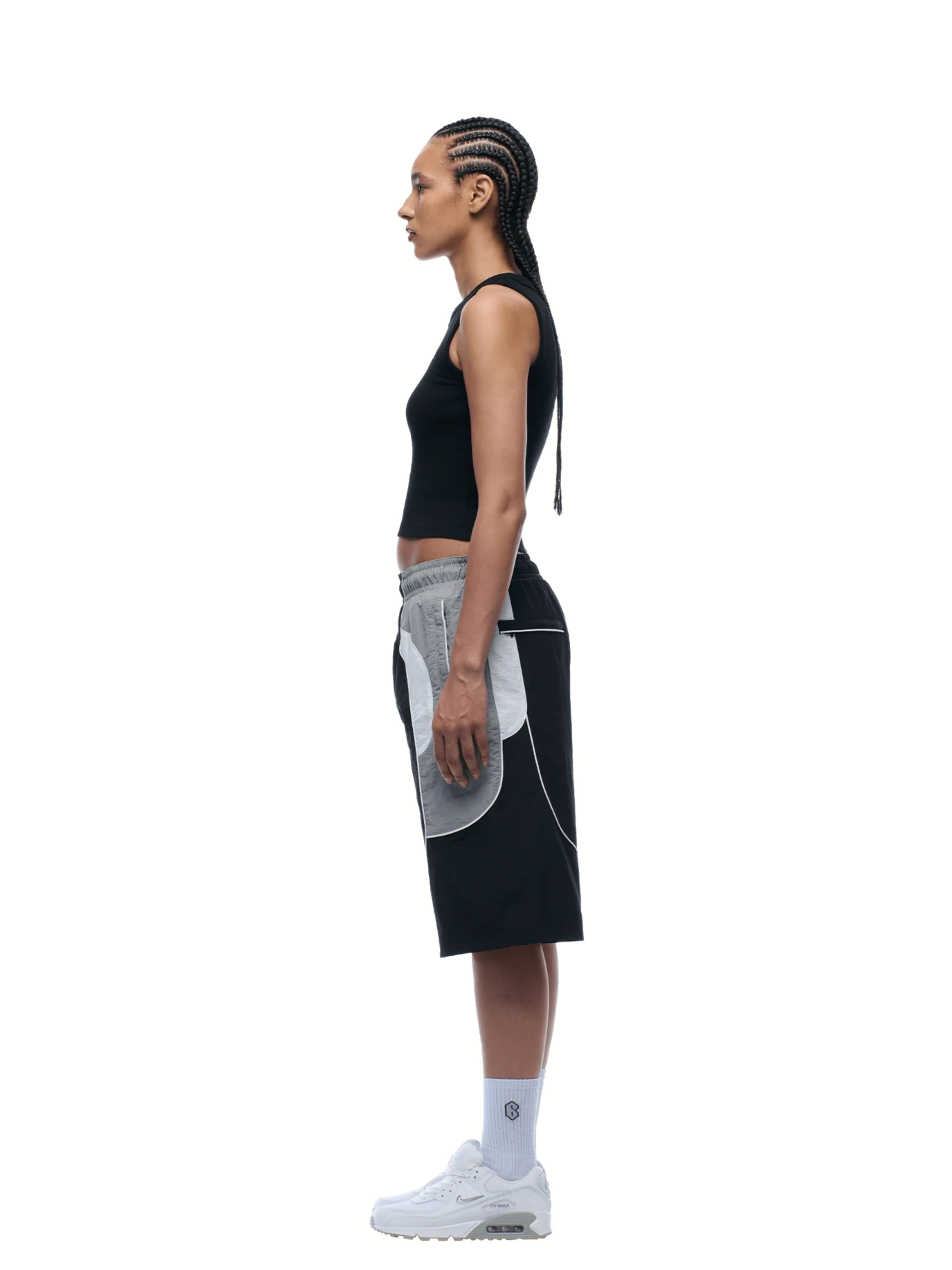 Person wearing a black and gray athletic outfit on a white background