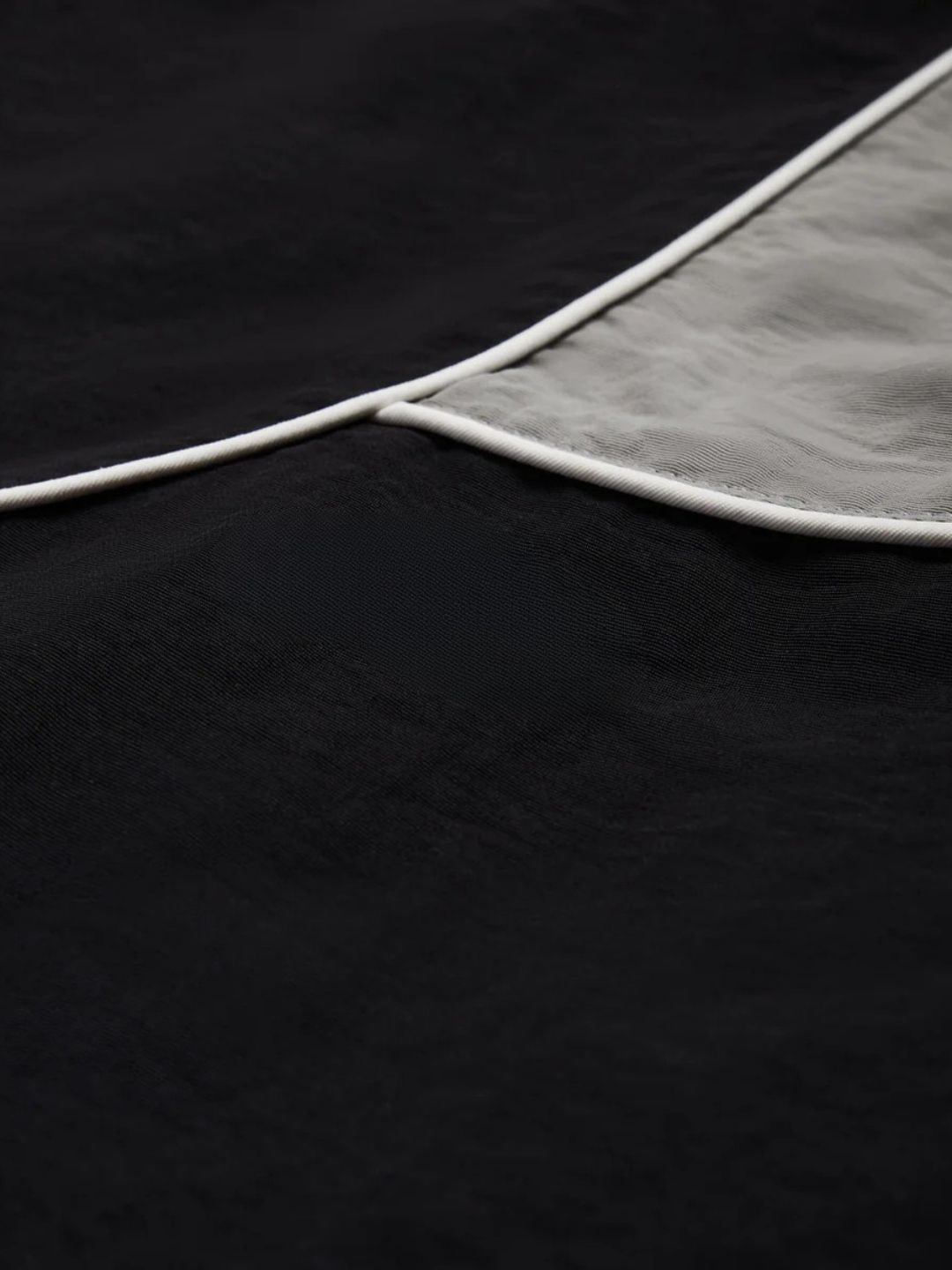 Close-up of a black fabric with a white edge on a dark background