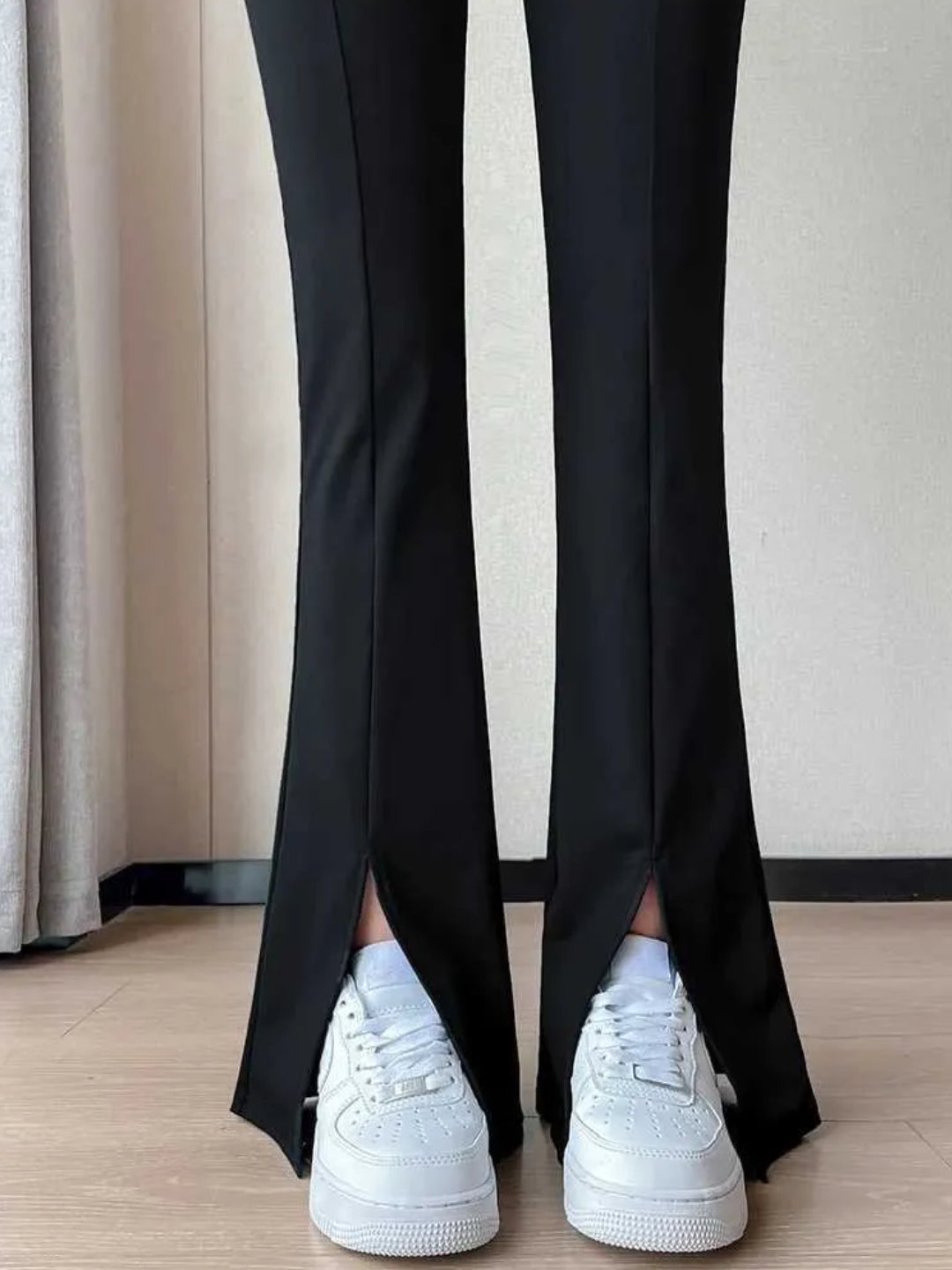 high-waist black yoga pants with a front slit, paired with white sneakers