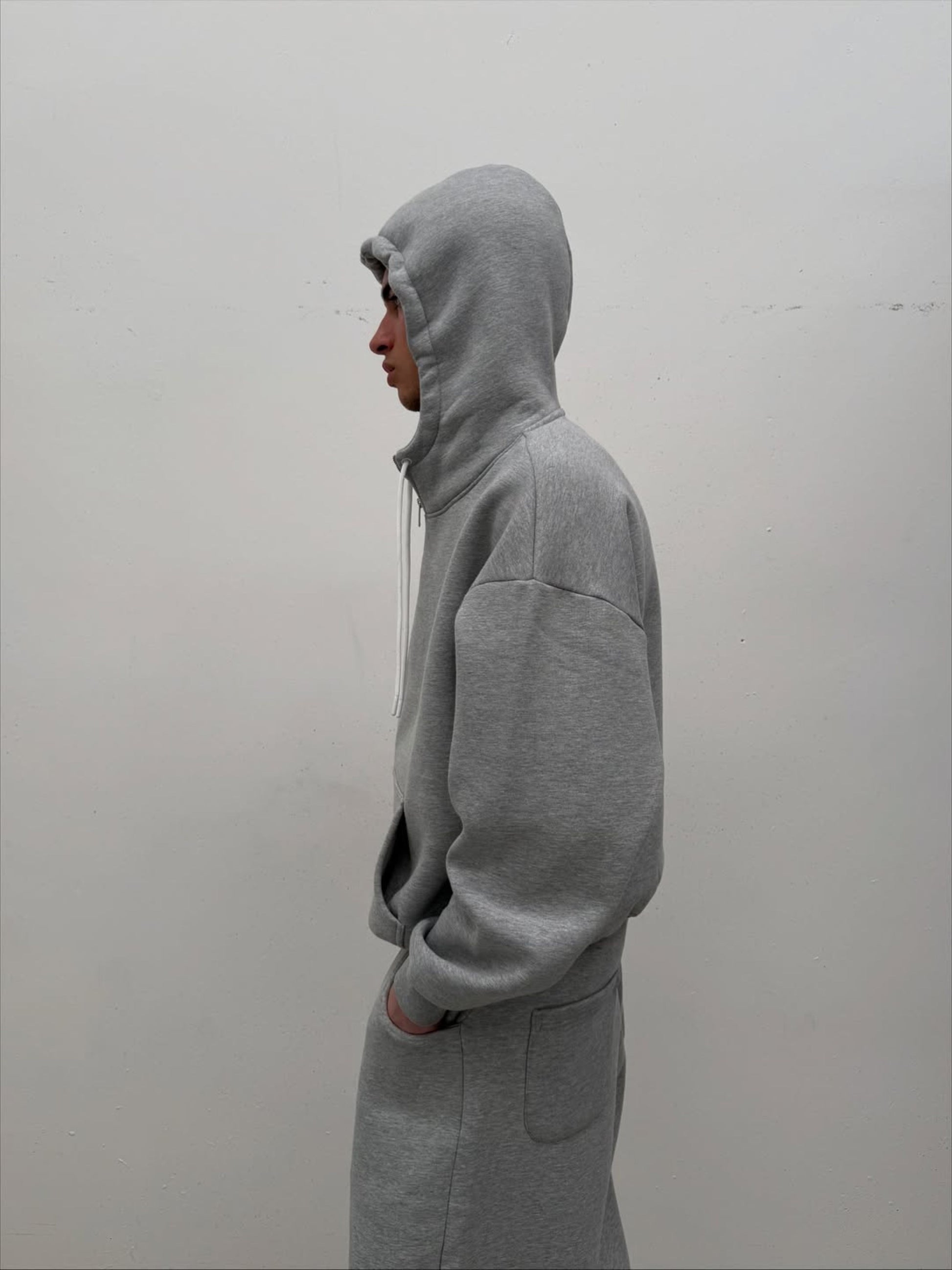 Person wearing a gray hoodie against a plain background