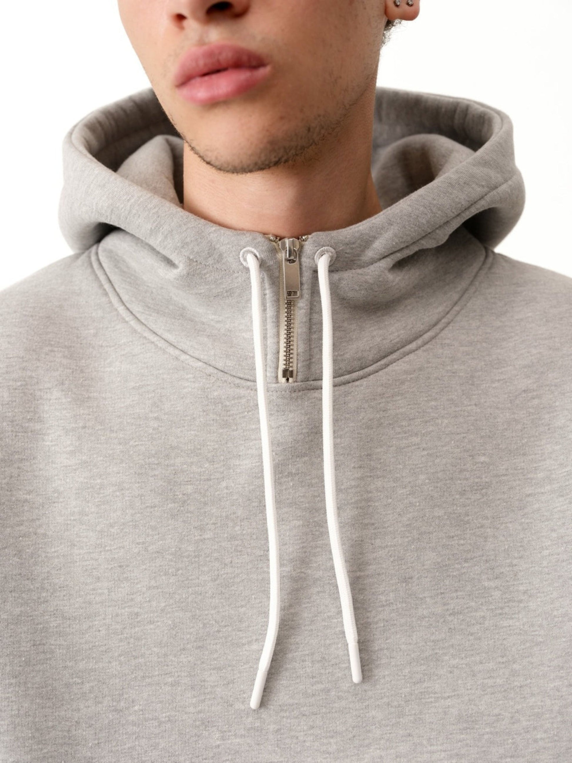 Gray hoodie with a zipper and white drawstrings on a white background