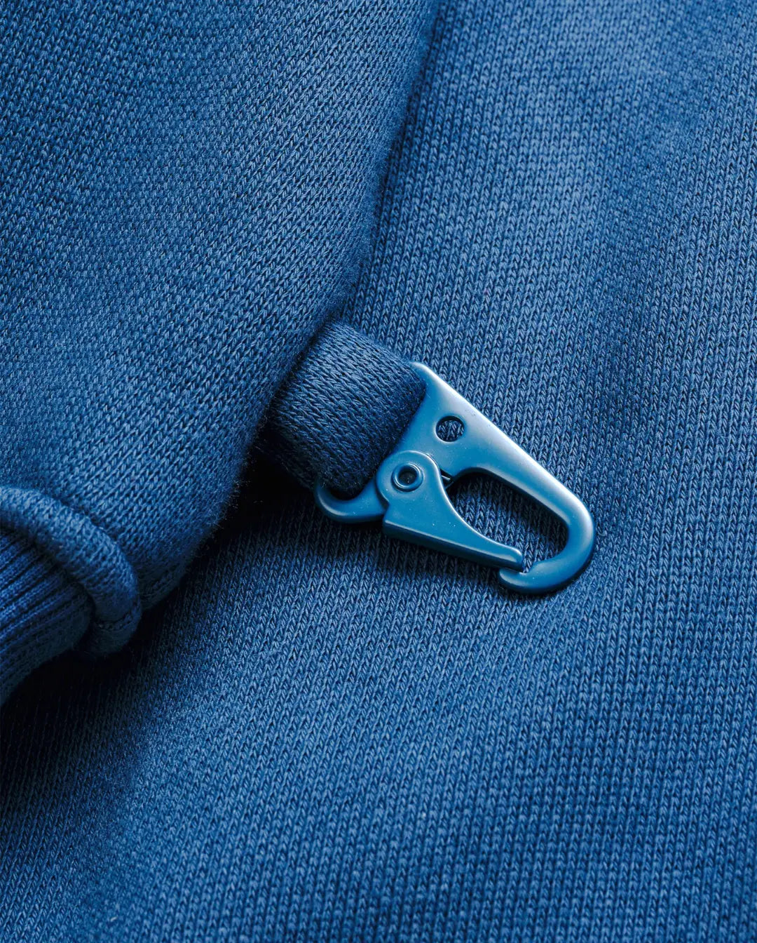 Close-up of a blue carabiner attached to a blue fabric