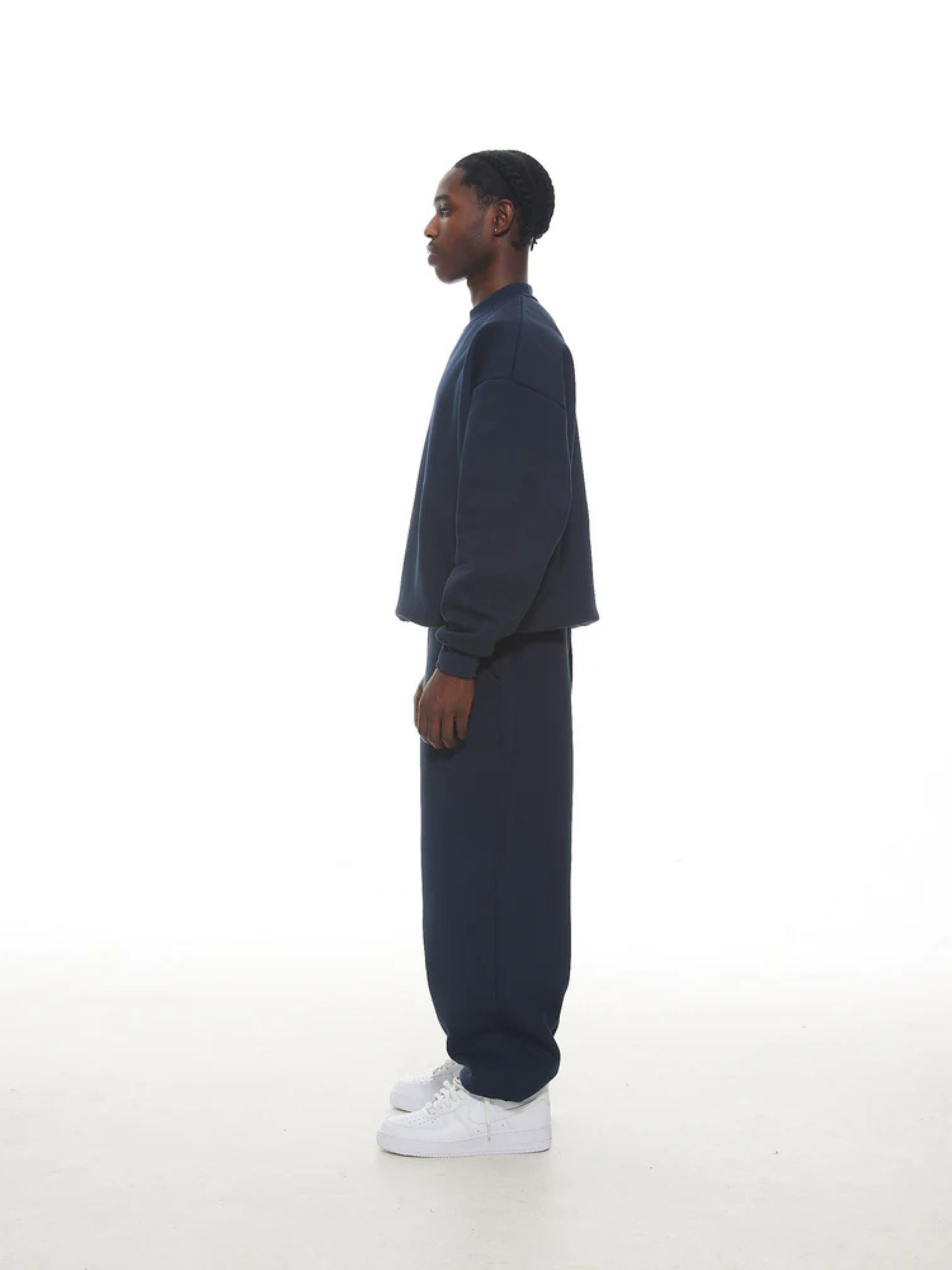 Person wearing a navy blue outfit on a white background