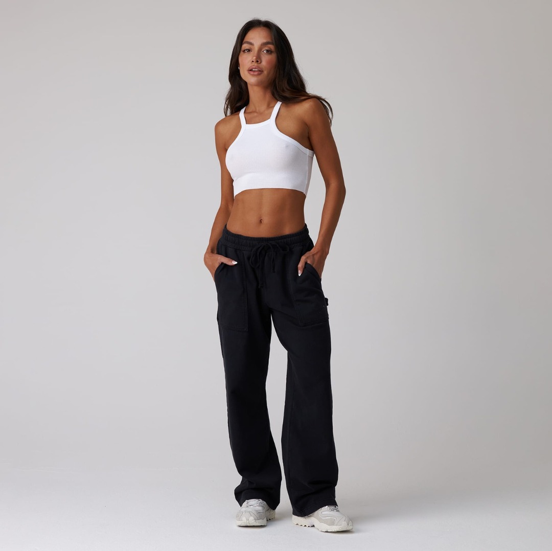 black jersey carpenter sweatpants with an adjustable toggle hem at the ankle, featuring multiple pockets.
