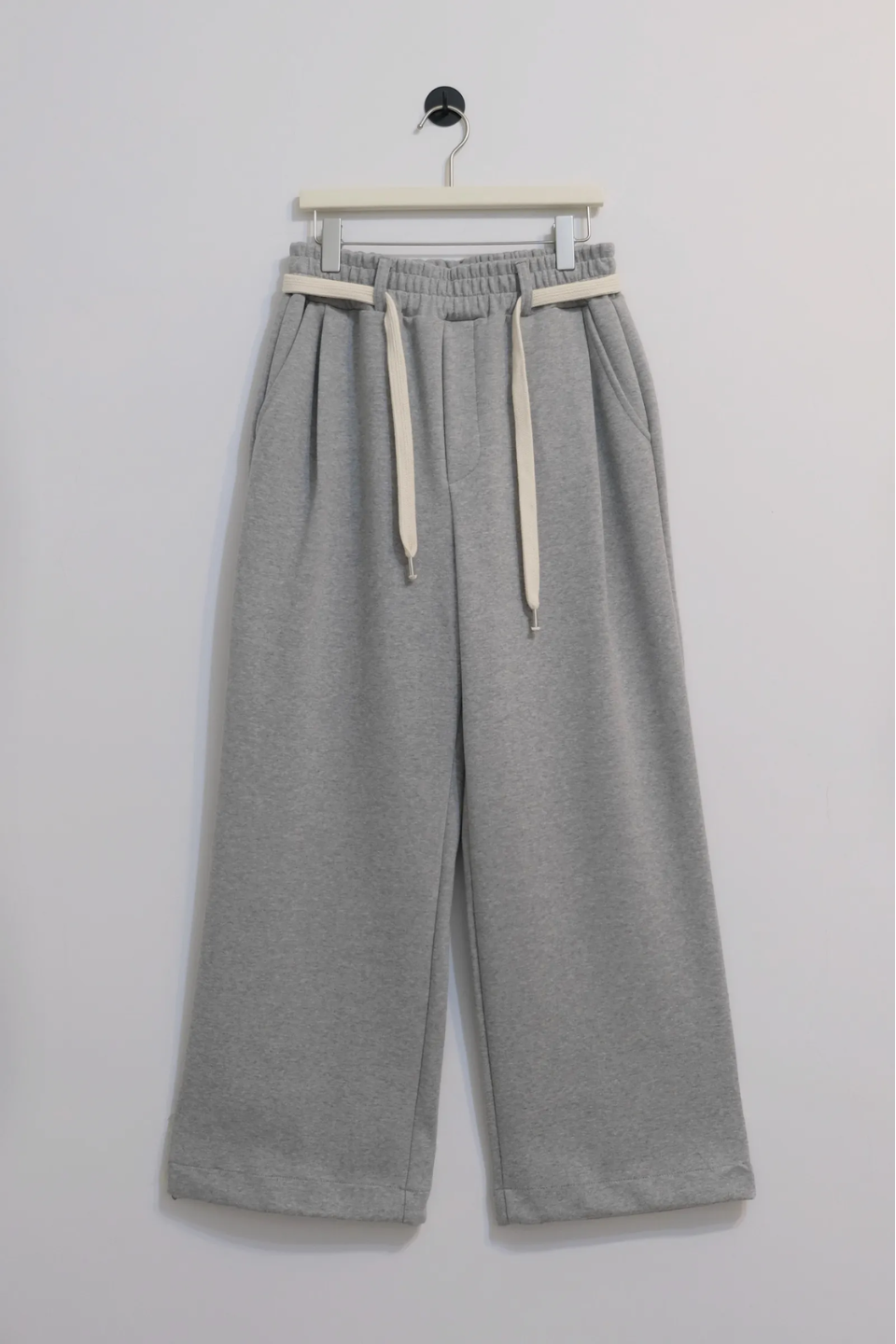 wide leg gray pants with a cotton belt, a white top, and black shoes.