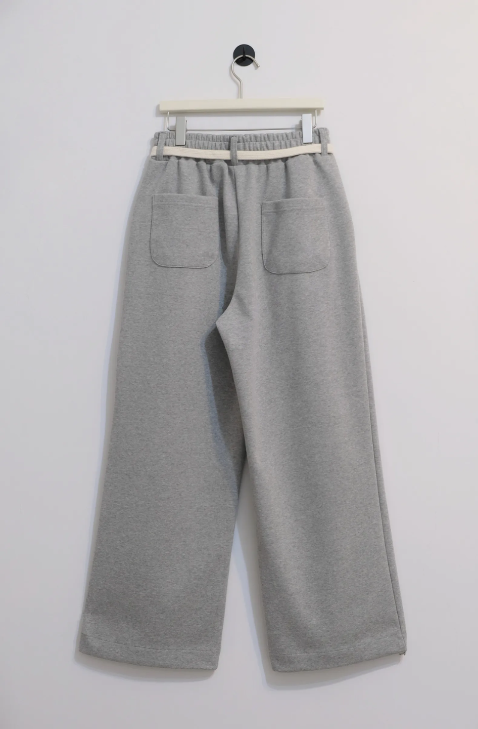 wide leg gray pants with a cotton belt, a white top, and black shoes.