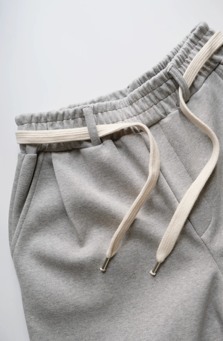 wide leg gray pants with a cotton belt, a white top, and black shoes.