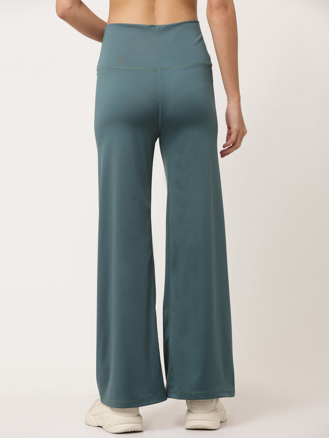 A model wearing green flared high-rise full-length yoga pants with a solid pattern.