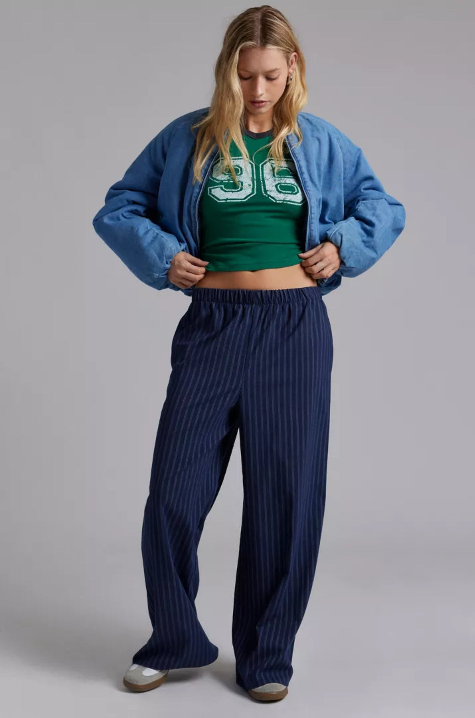 A woman wearing a green crop top with a bold '96' graphic in white.