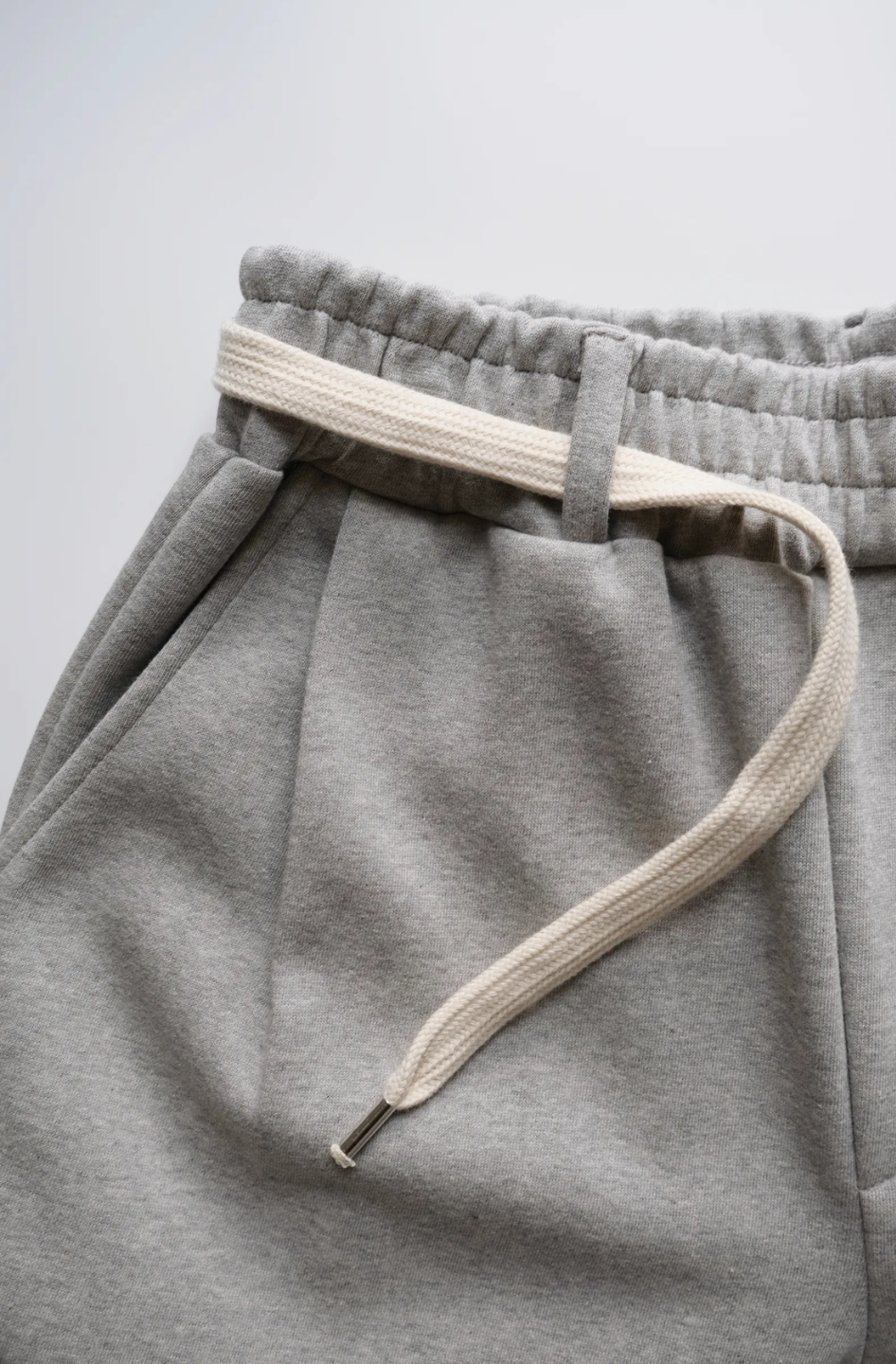 wide leg gray pants with a cotton belt, a white top, and black shoes.