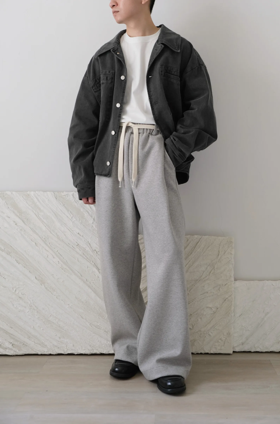 wide leg gray pants with a cotton belt, a white top, and black shoes.