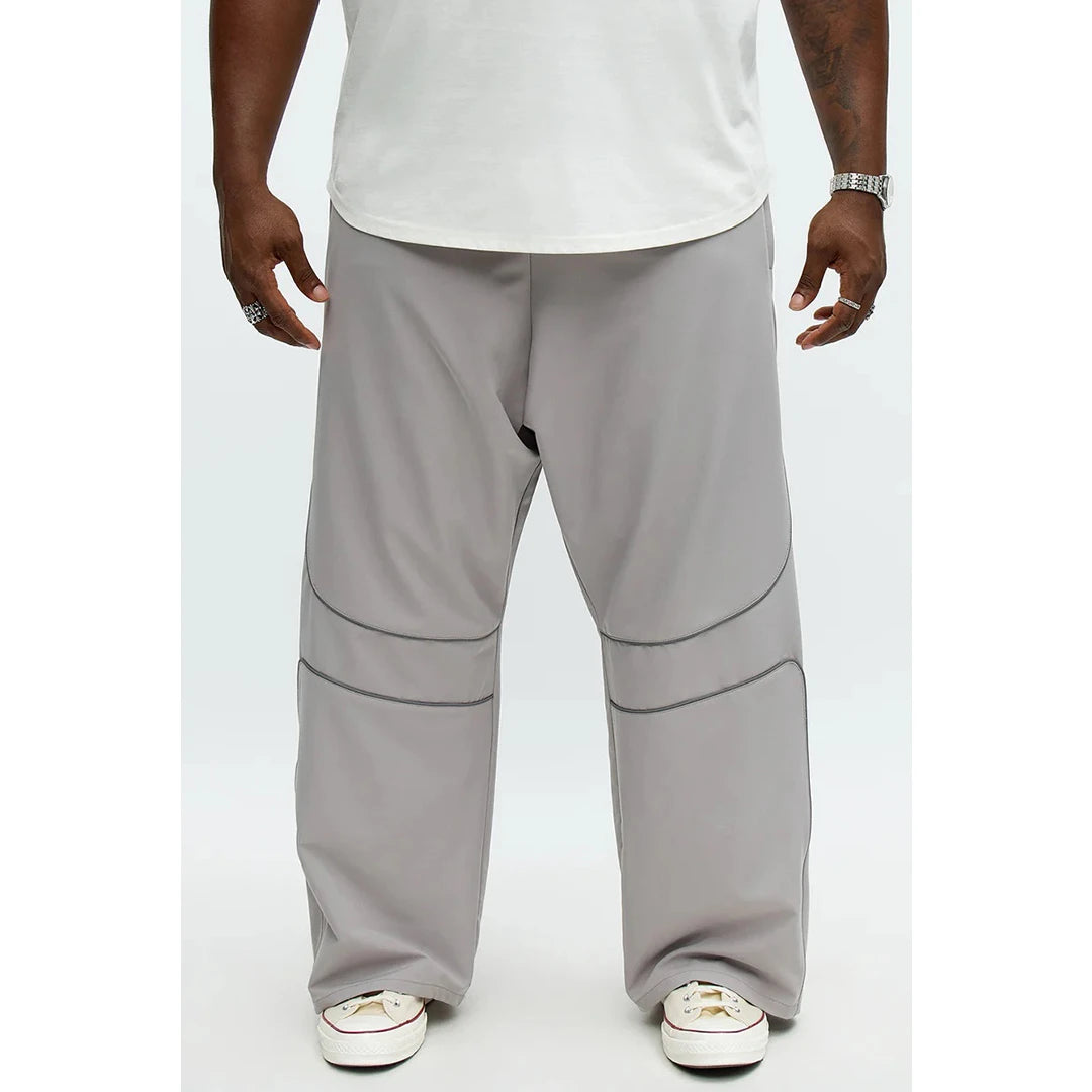 Person wearing gray pants and white shoes on a white background