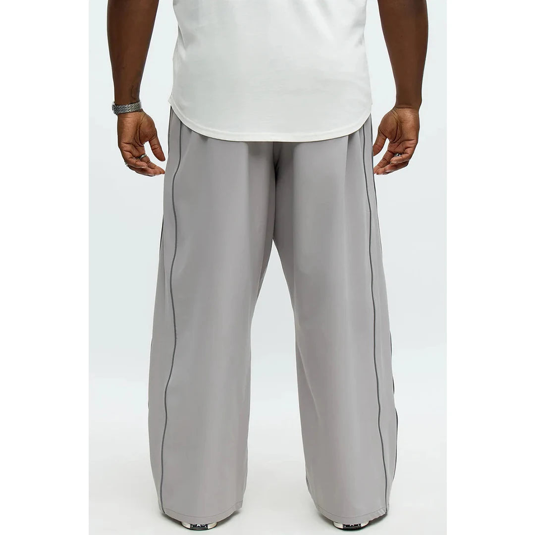 Person wearing gray wide-leg pants and a white shirt on a white background
