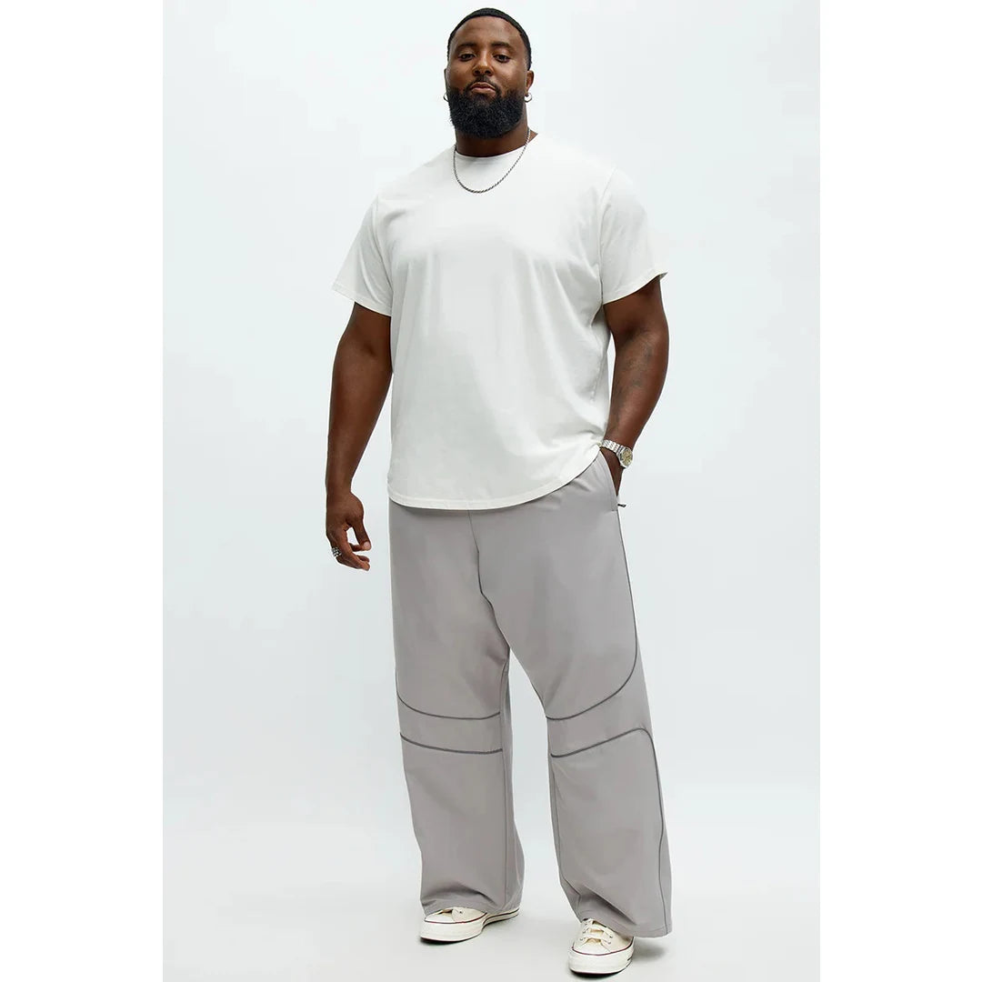 Person wearing a white t-shirt and gray pants on a white background
