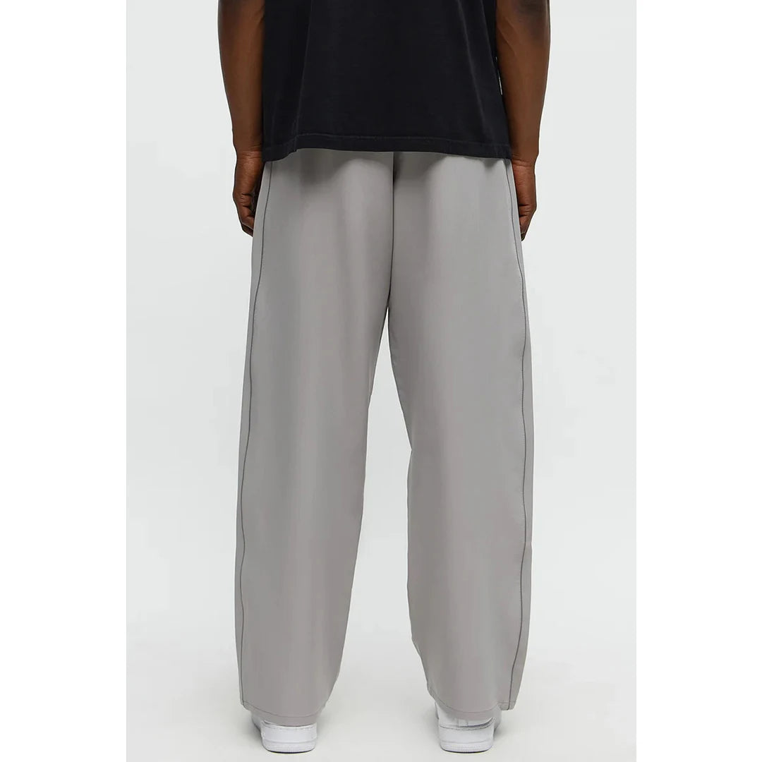 Person wearing light gray wide-leg pants on a white background