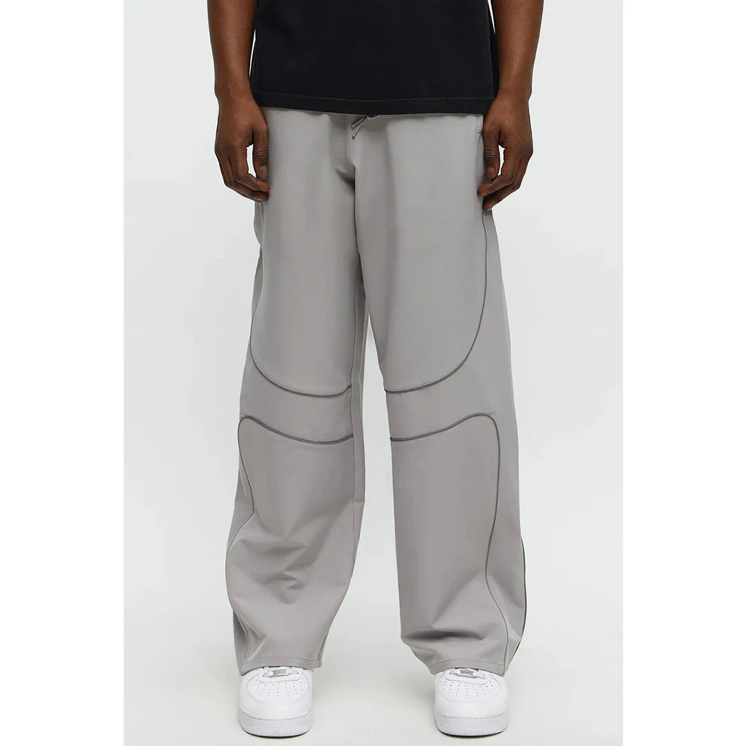 Person wearing gray pants with a plain background