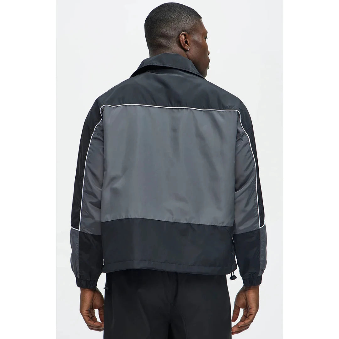 Person wearing a black and gray jacket on a white background