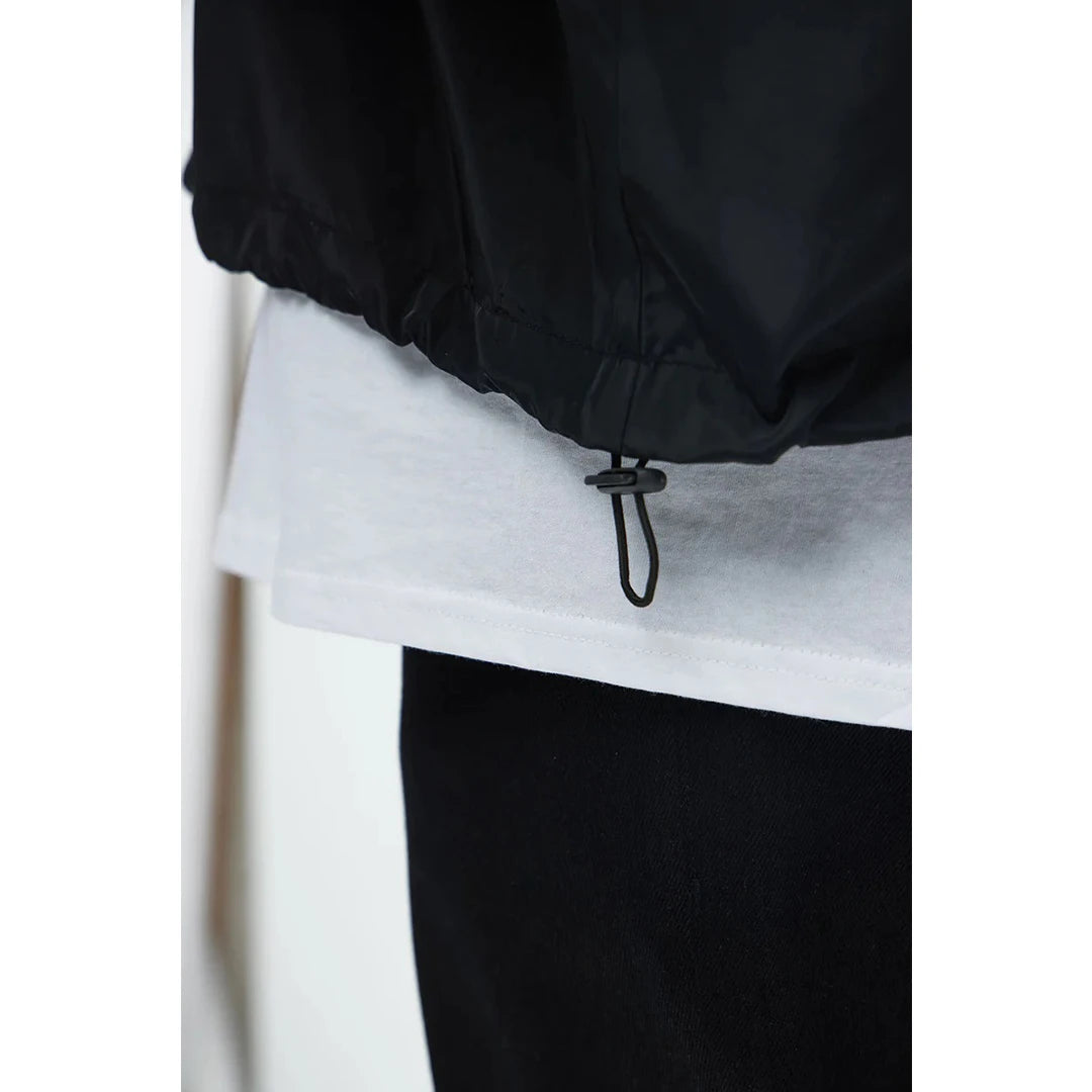 Close-up of a black jacket with a white shirt underneath on a white background