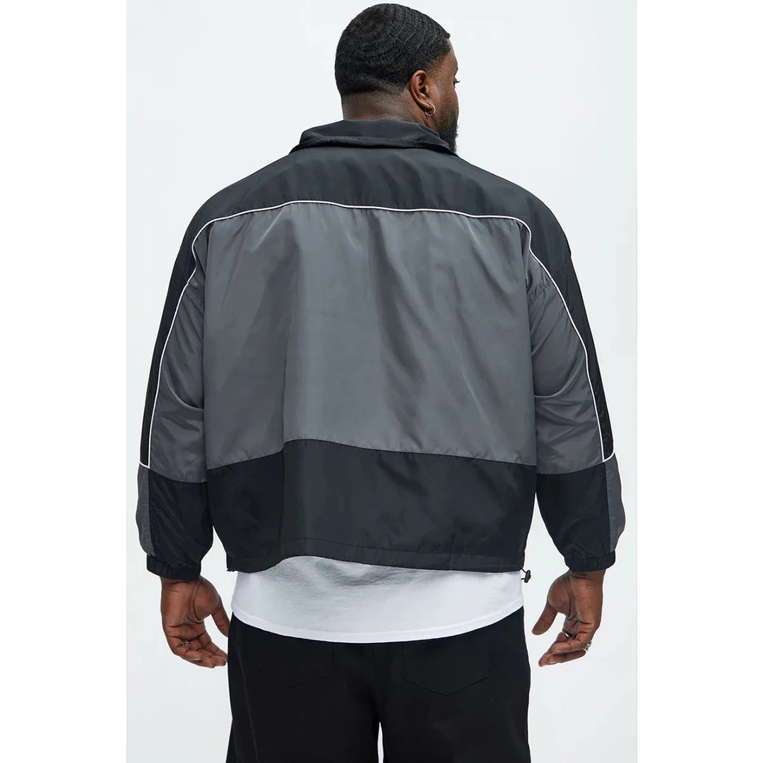 Person wearing a black and gray jacket on a white background