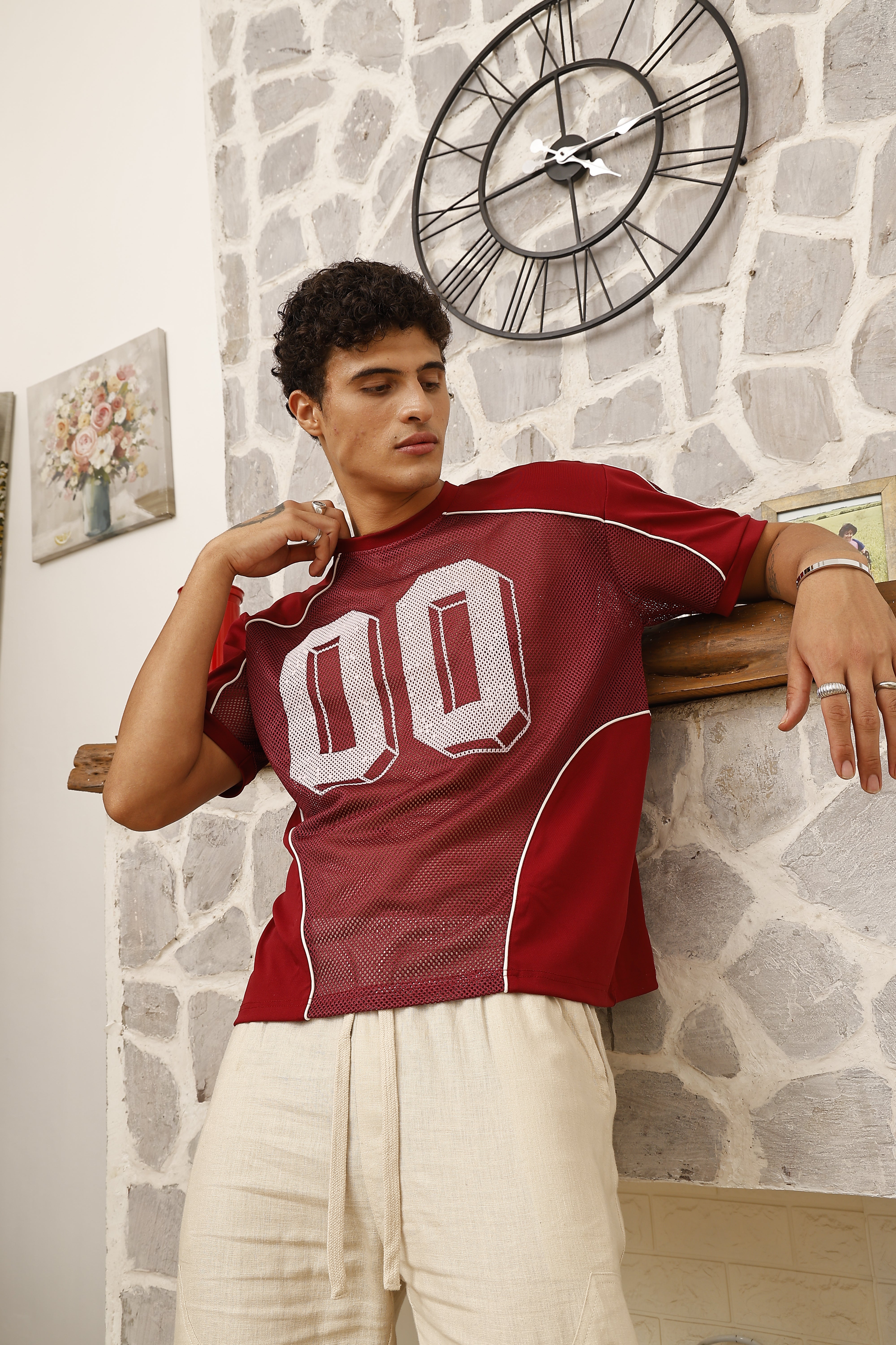 Person wearing a red sports jersey with white numbers on a stone floor.
