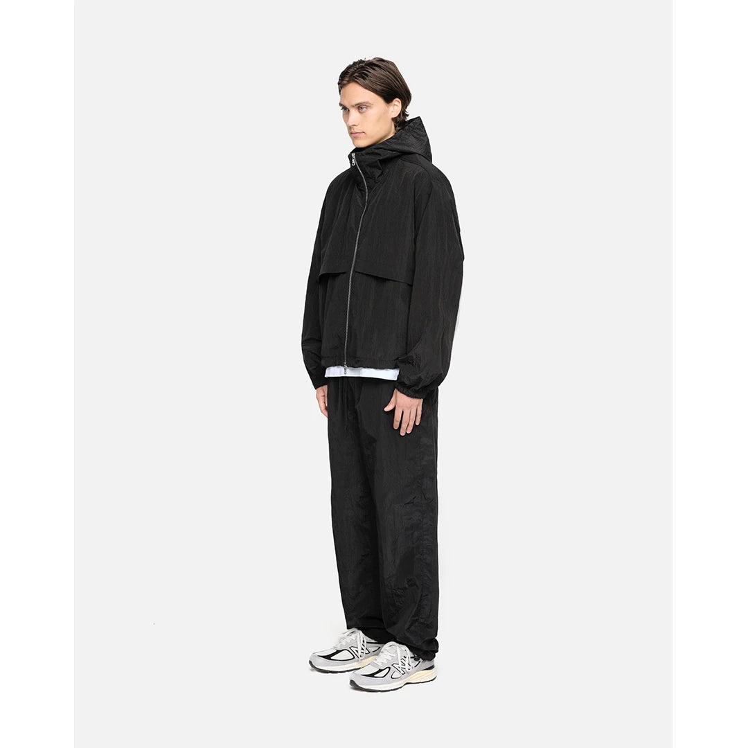 Person wearing a black tracksuit on a white background