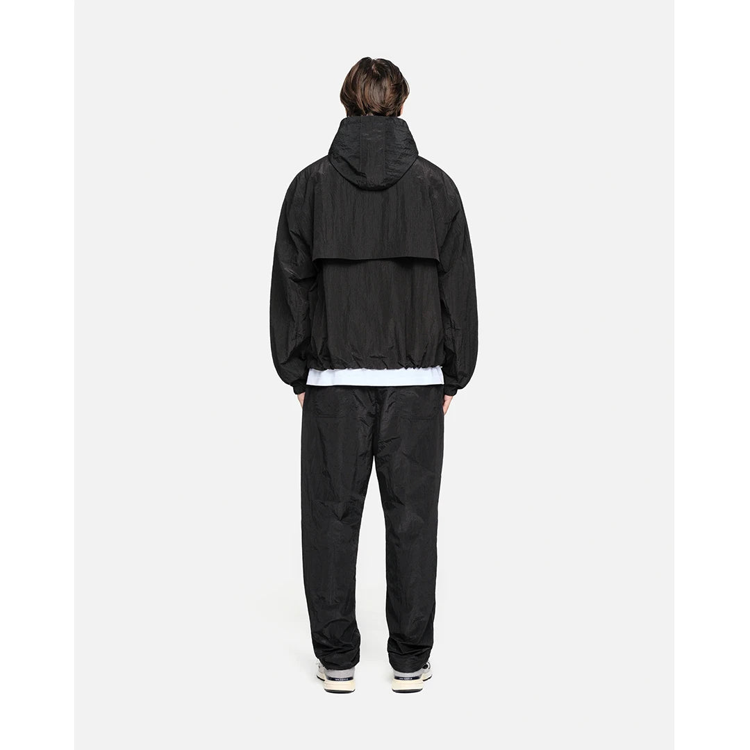 Person wearing a black tracksuit on a white background