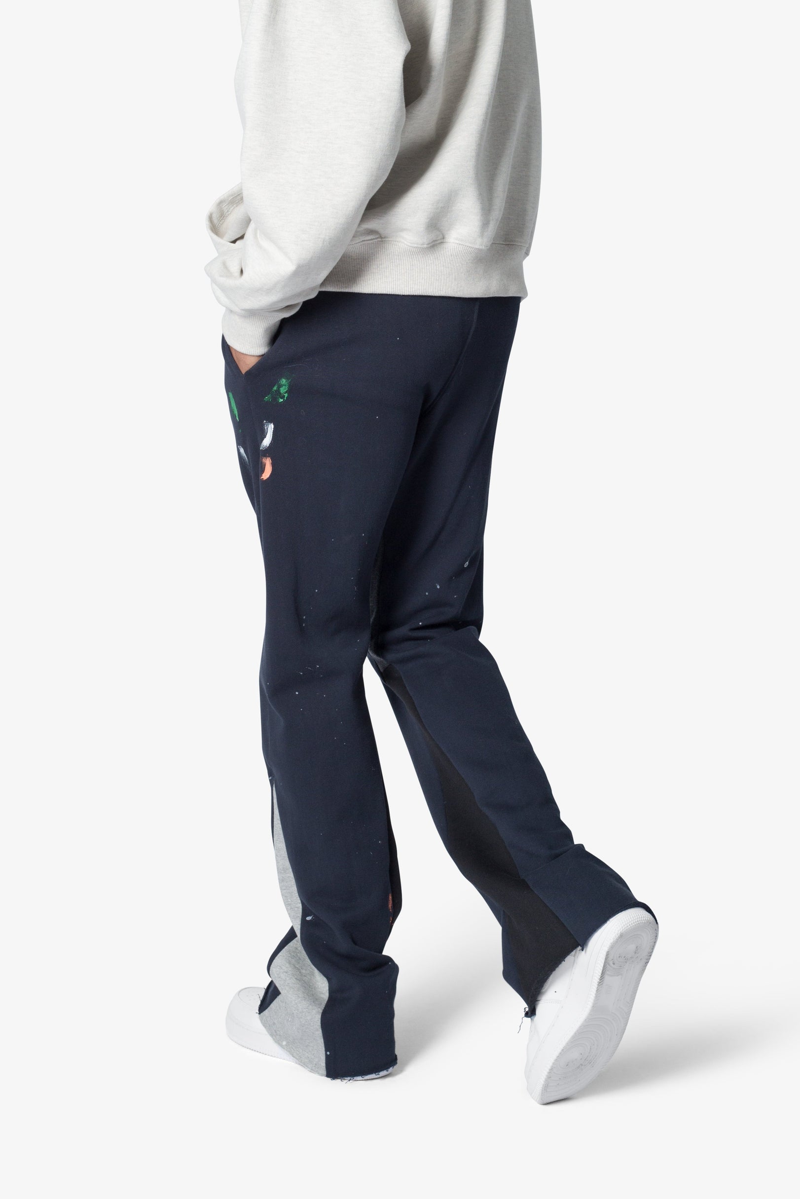 Person wearing navy pants with a small colorful design on a white background