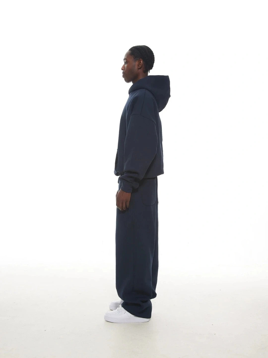 Person wearing a navy tracksuit on a white background