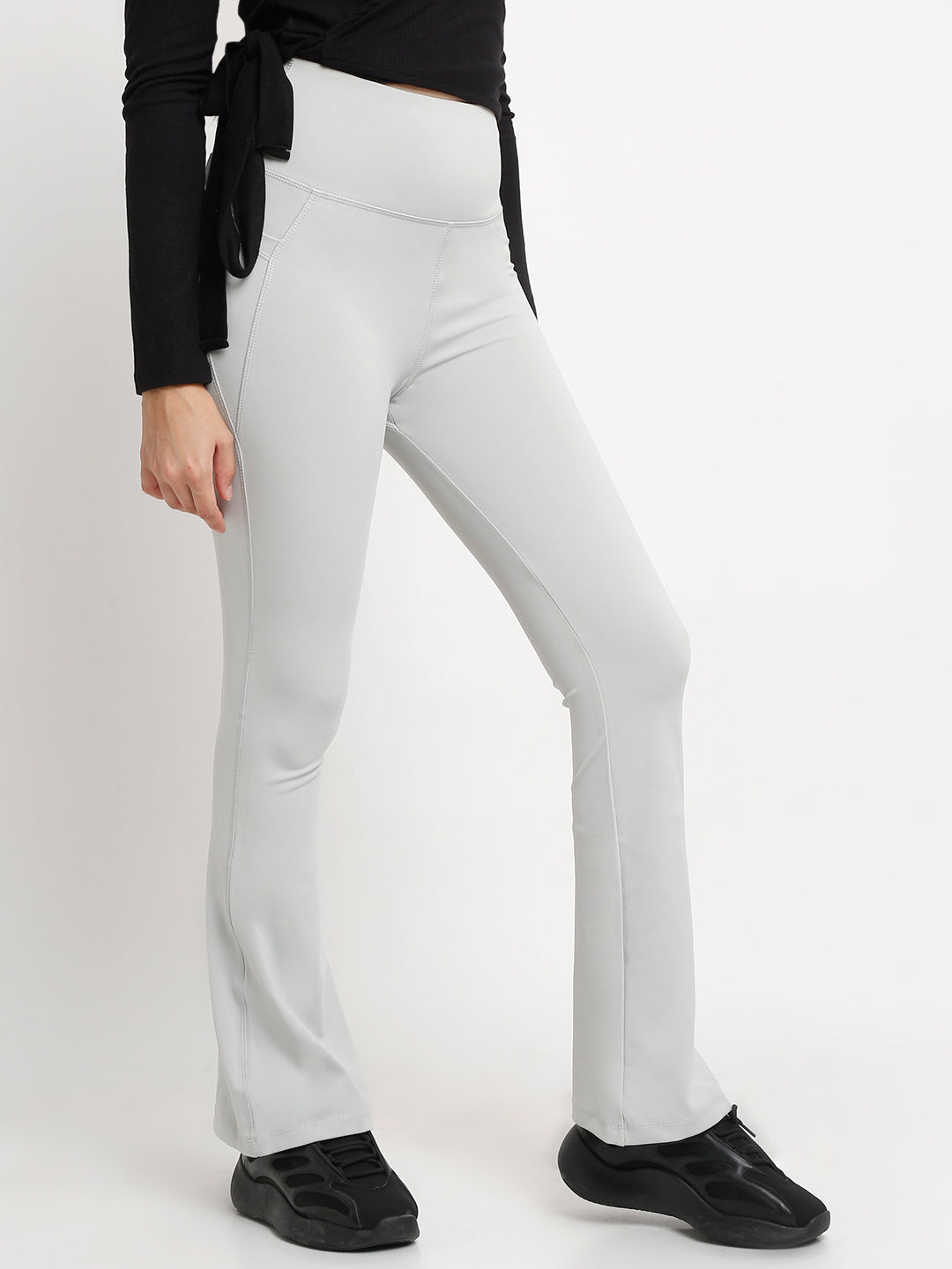 A pair of high-waisted grey flare pants with pockets, in a bootcut style.