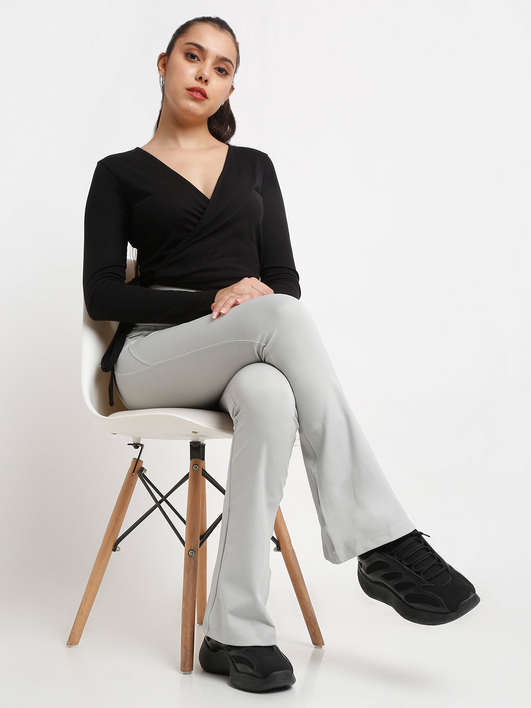 A pair of high-waisted grey flare pants with pockets, in a bootcut style.