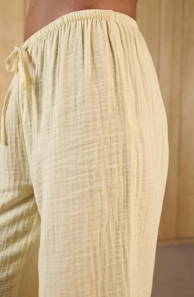 Beige textured pants with drawstring waist on a neutral background