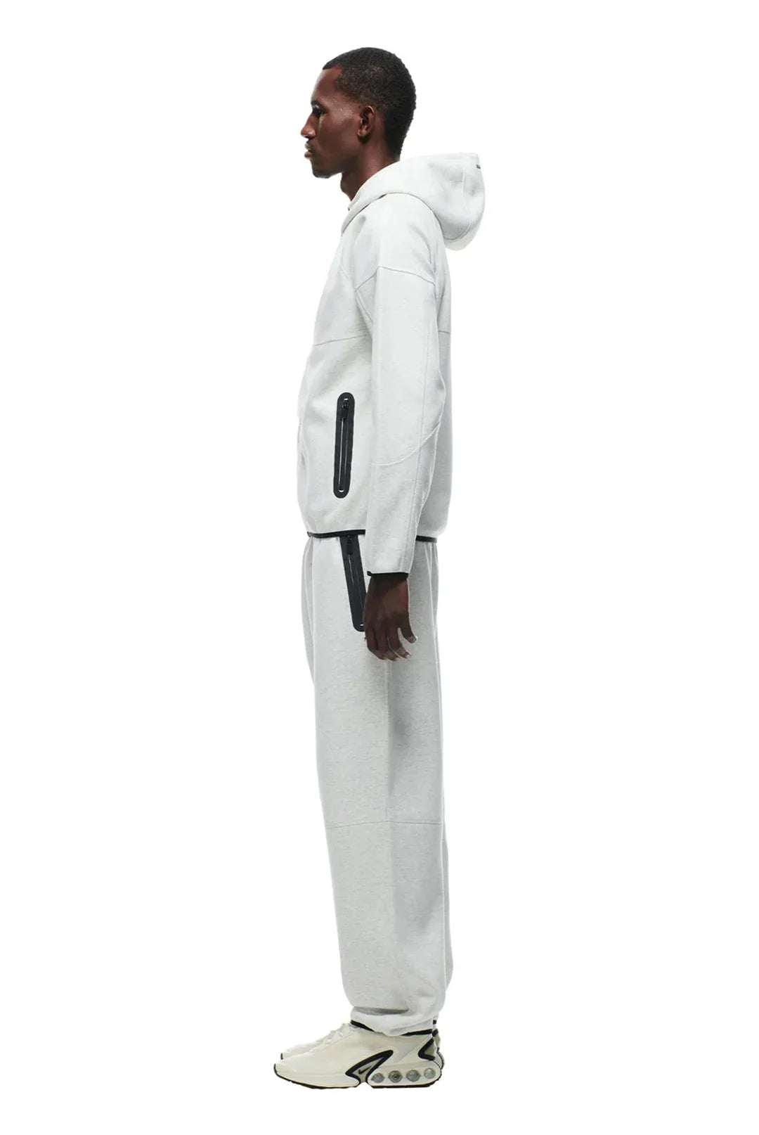 Person wearing a white outfit with black accents on a white background