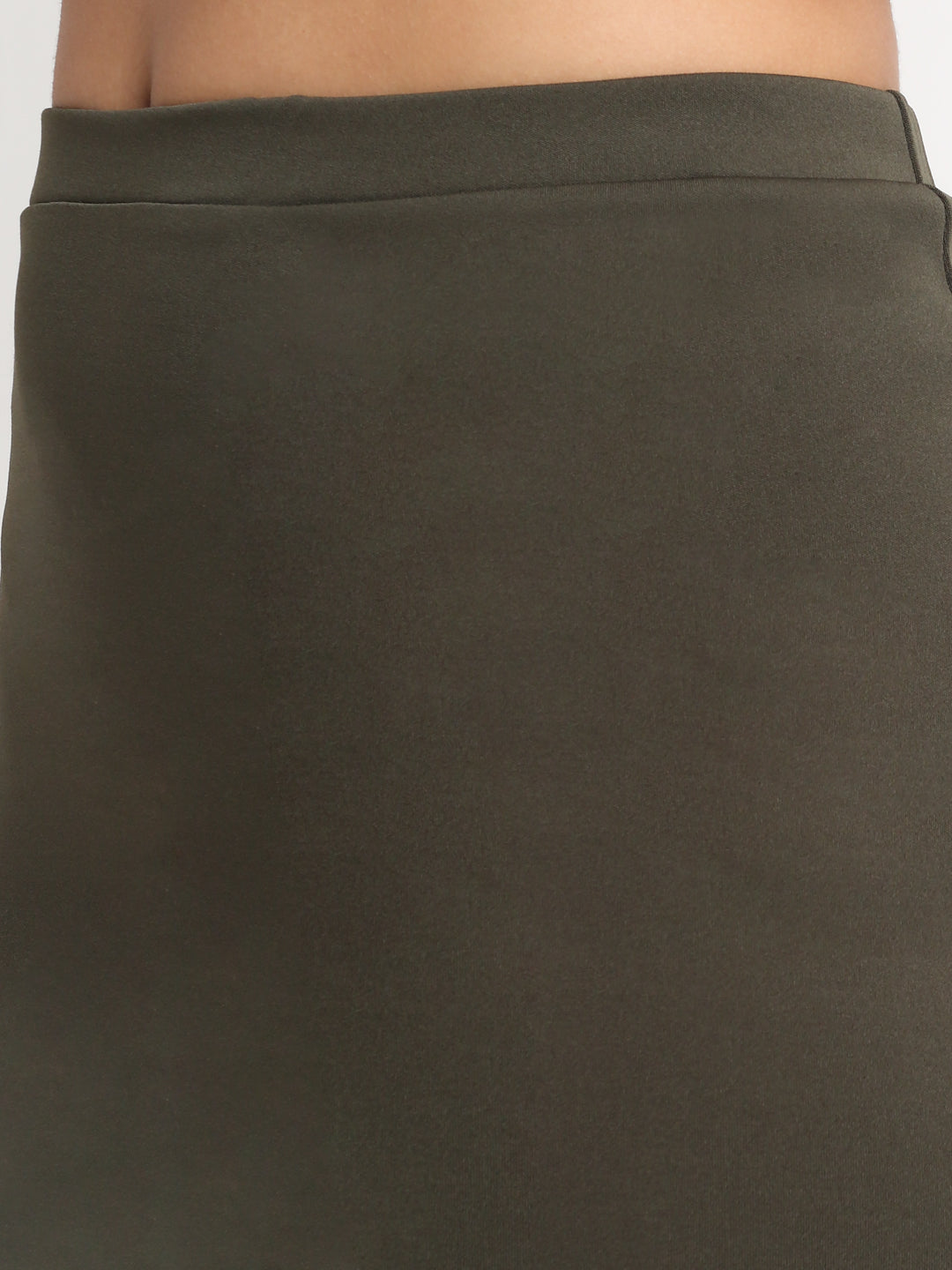 A high-rise mini side slit skirt in green, worn by a person with white shoes.