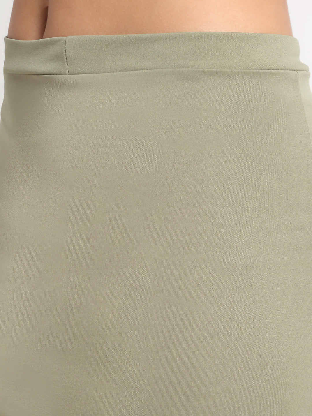 A high-rise mini side slit skirt in green, worn by a person with white shoes.