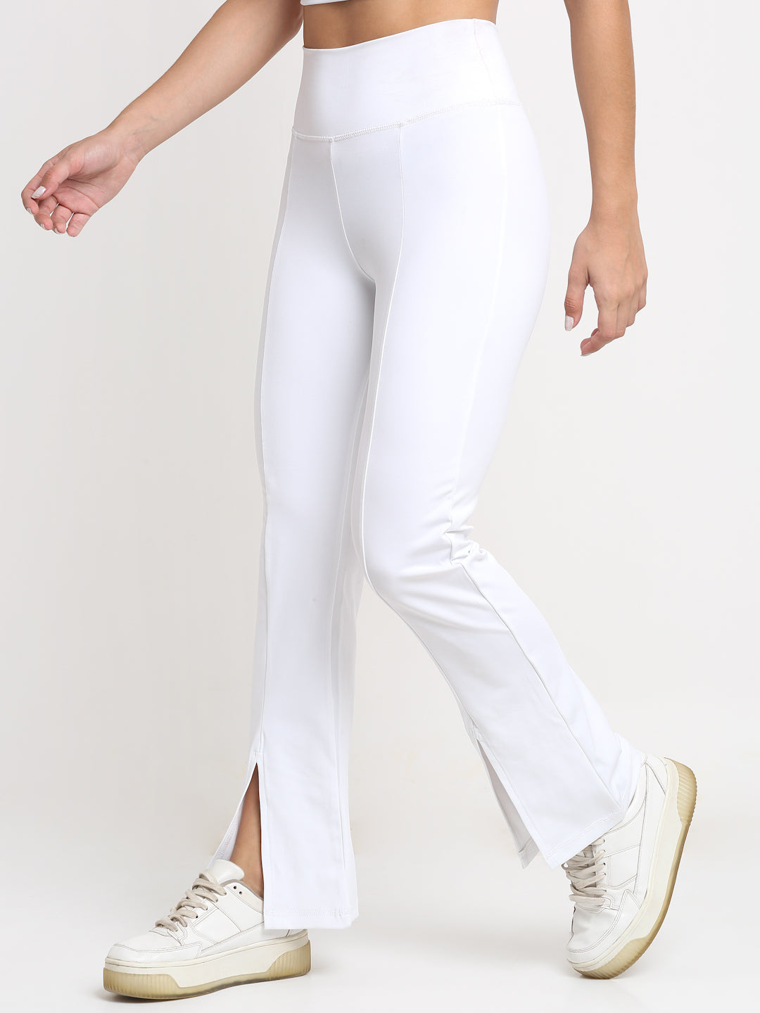 High-waisted White yoga pants with a front slit, featuring a skinny waistband and elevated front seams. The pants are designed with a flared